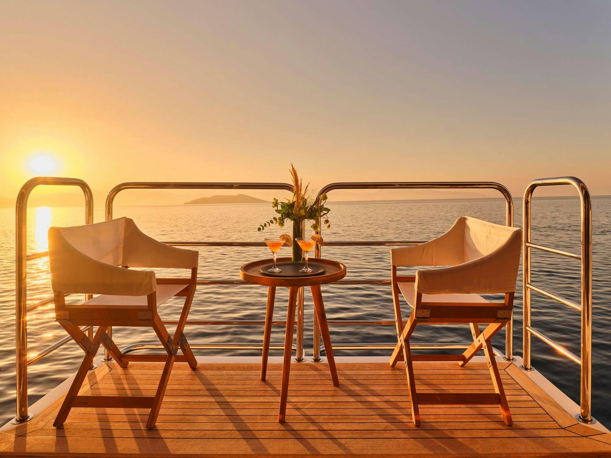 a couple chairs on a deck overlooking the ocean aboard MAKANI II Yacht for Charter