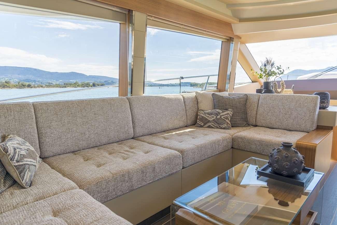 a couch and a coffee table in a room with a large window aboard SIR HENDRIK Yacht for Charter