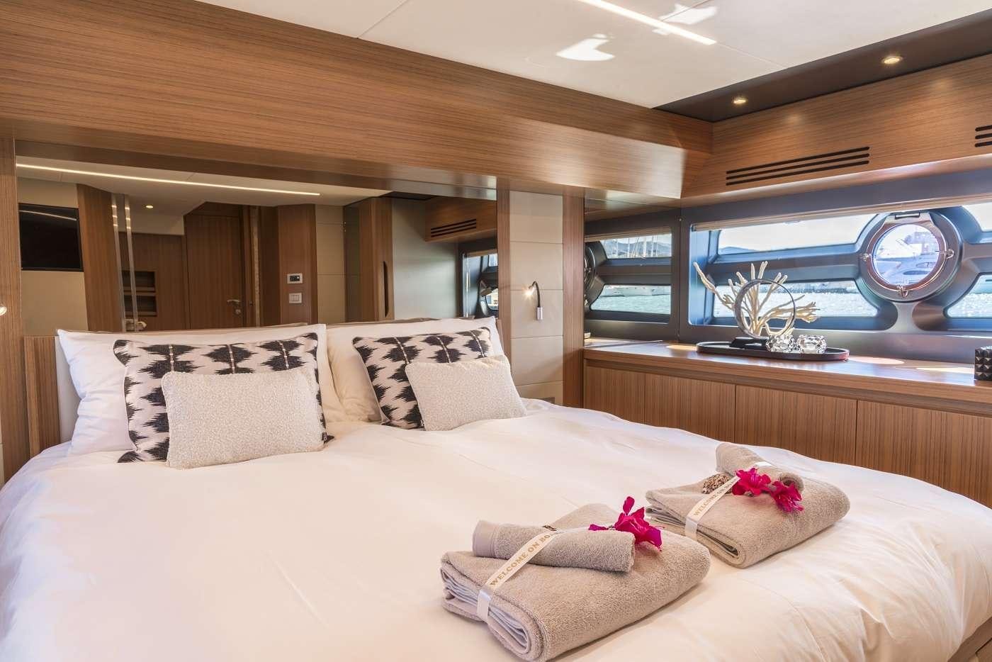 a bed with pillows and a flower on the bed aboard SIR HENDRIK Yacht for Charter