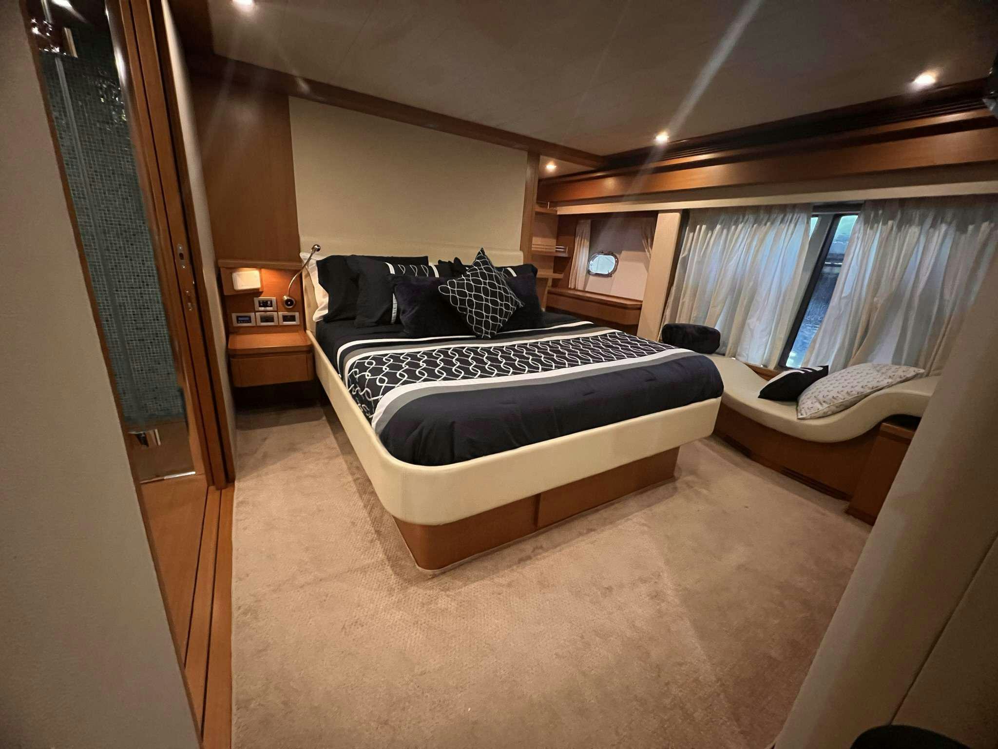 a bedroom with a bed and a window aboard DESTINY Yacht for Charter