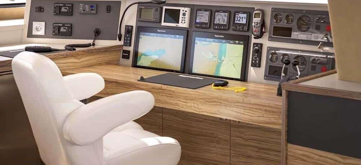 a person's hand holding a remote control in a control room aboard NEPTUNE Yacht for Charter