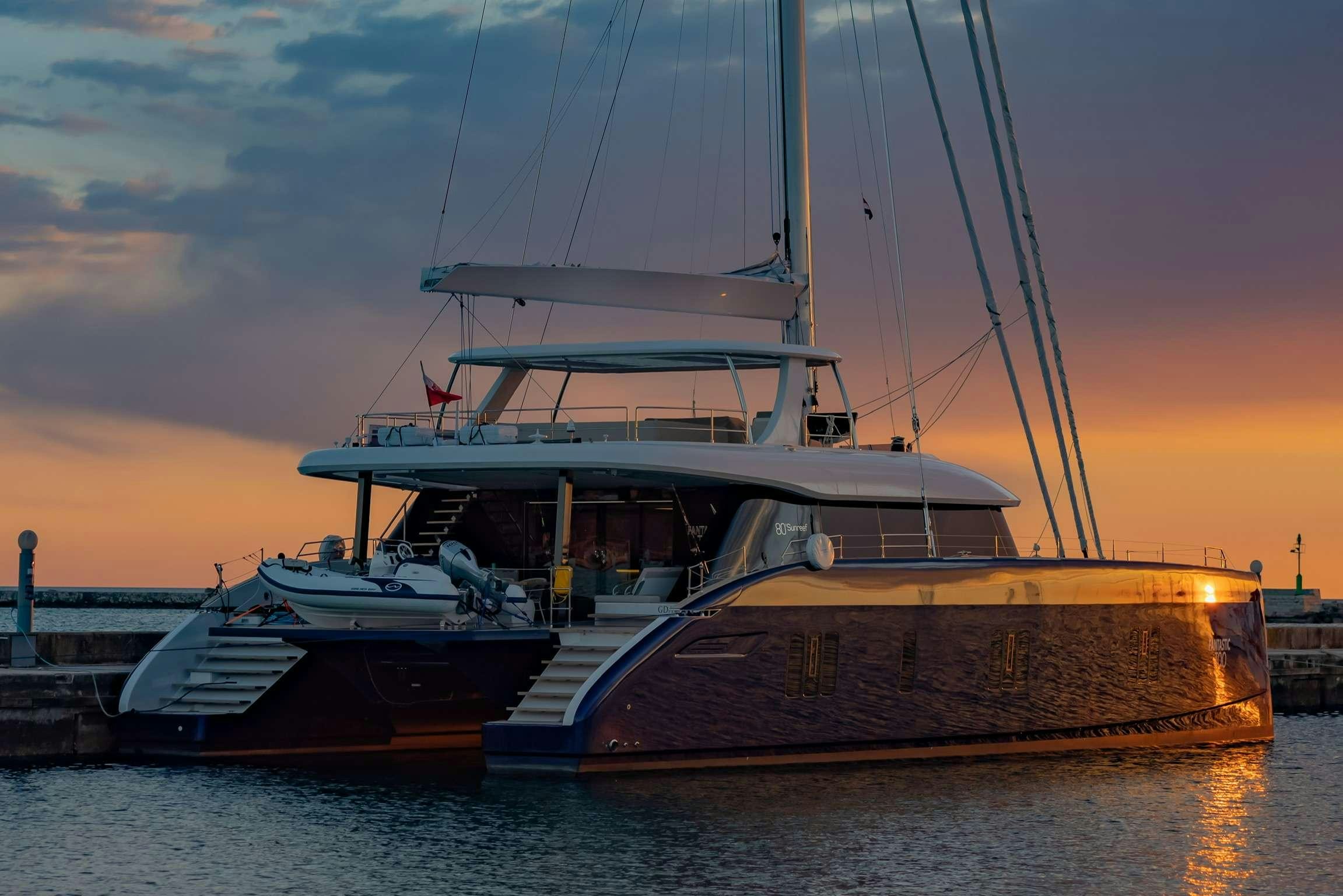 a large boat docked at a dock aboard SUNREEF 80 FANTASTIC TOO Yacht for Charter