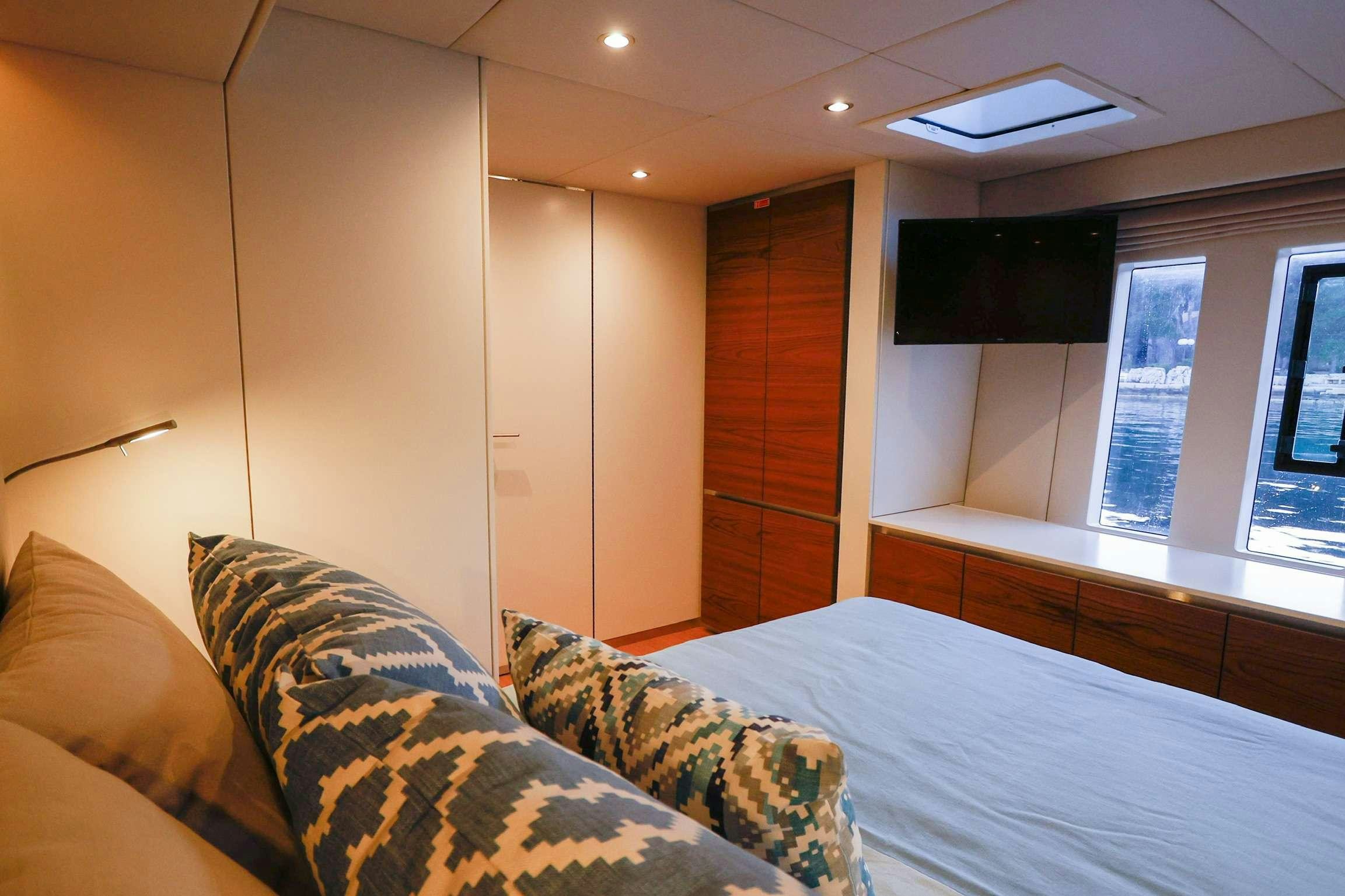 a bedroom with a bed and a wood door aboard SUNREEF 80 FANTASTIC TOO Yacht for Charter