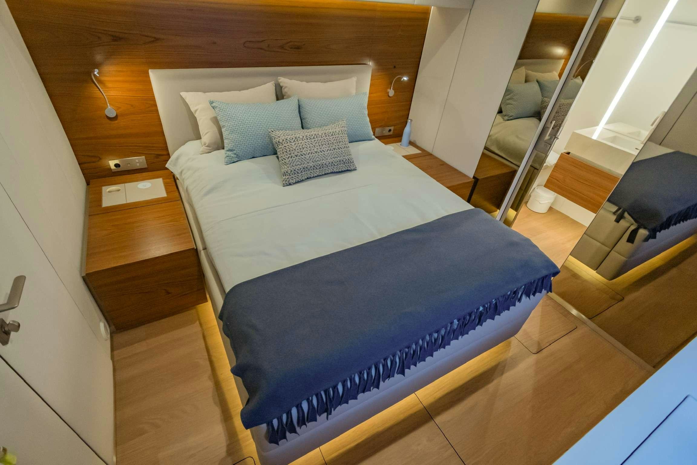 a bed with blue sheets aboard SUNREEF 80 FANTASTIC TOO Yacht for Charter