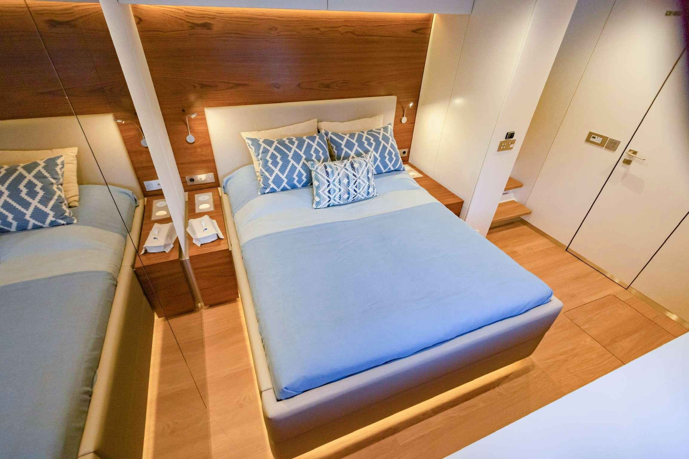 a bed with a blue comforter aboard SUNREEF 80 FANTASTIC TOO Yacht for Charter
