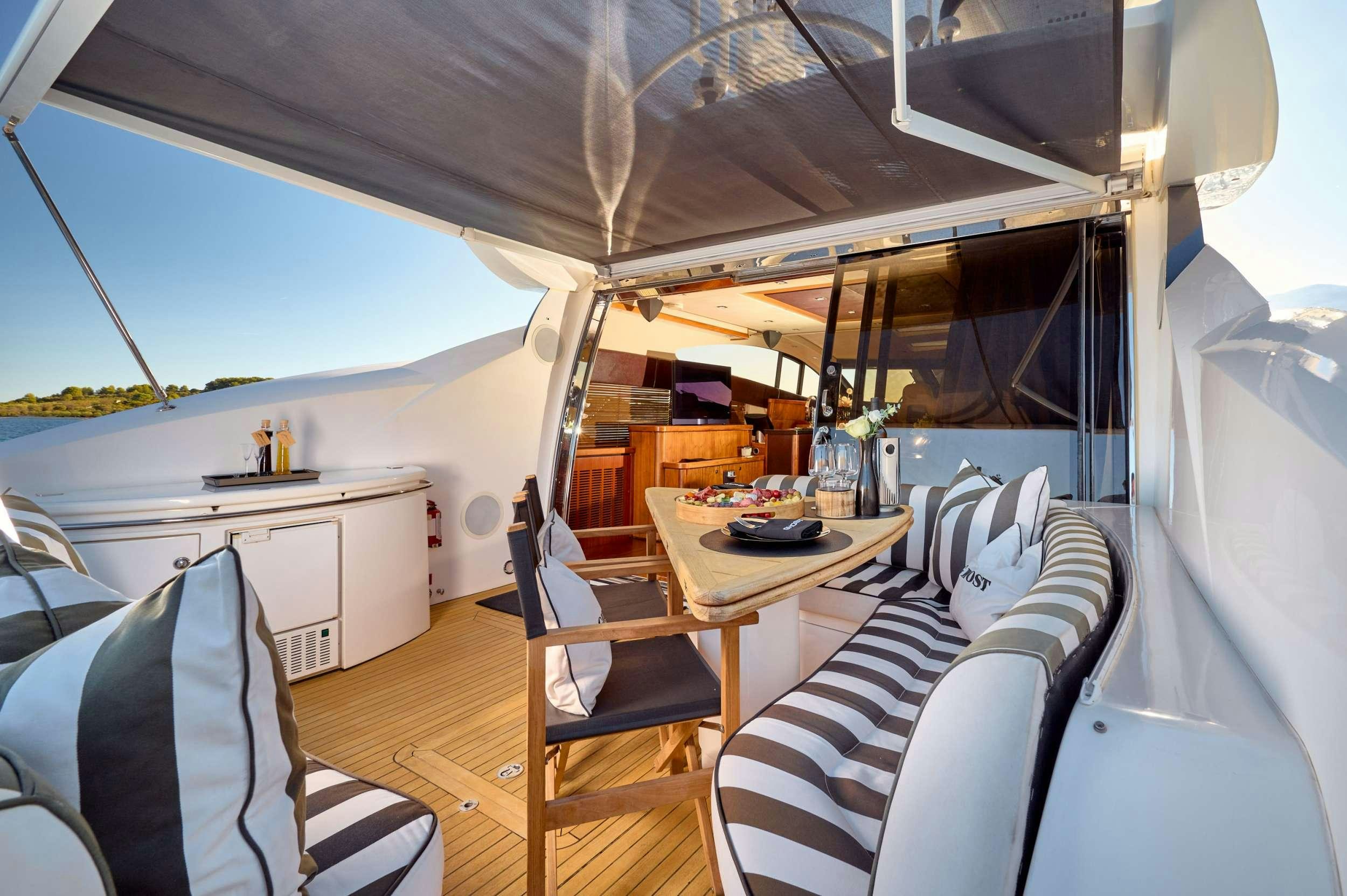 a boat with a table and chairs aboard SUNSEEKER PREDATOR 72 GHOST Yacht for Charter