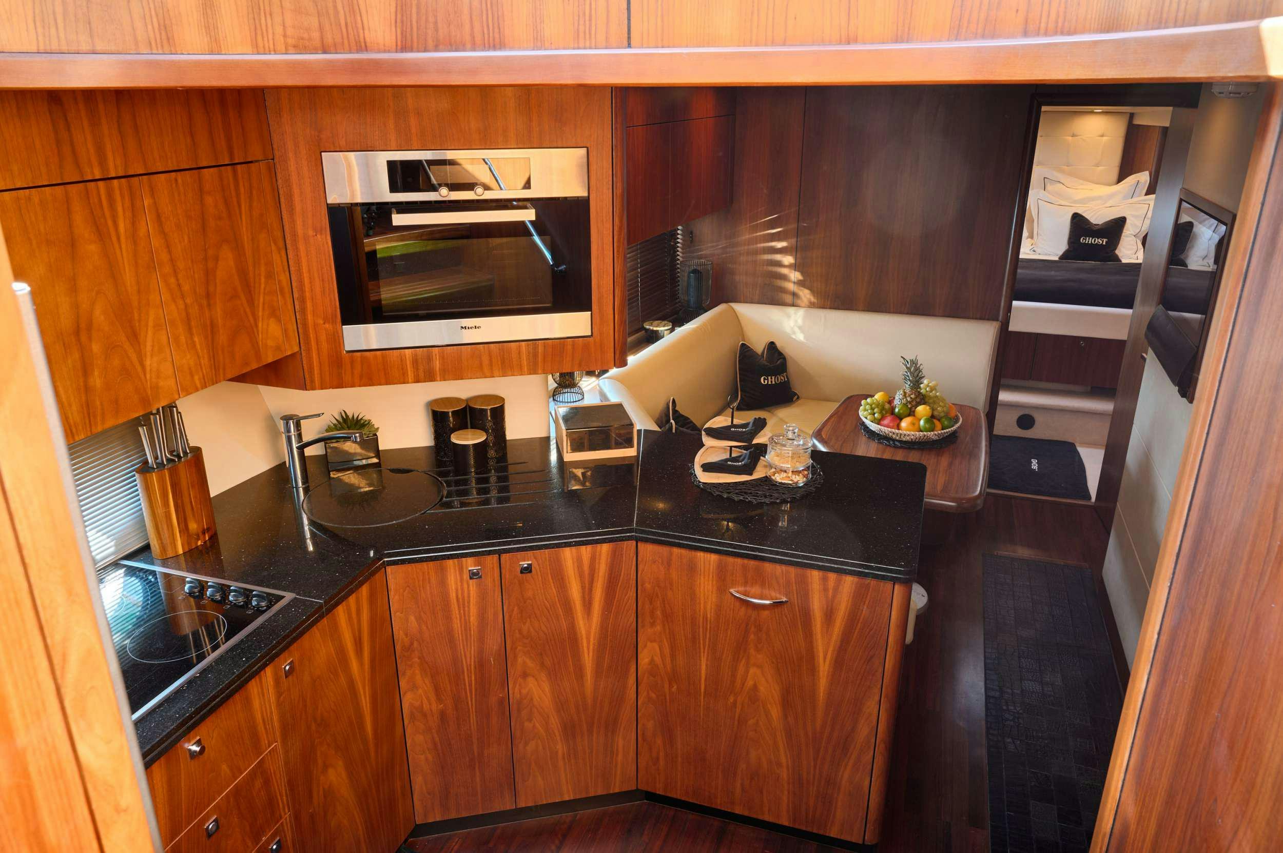 a kitchen with wooden cabinets aboard SUNSEEKER PREDATOR 72 GHOST Yacht for Charter