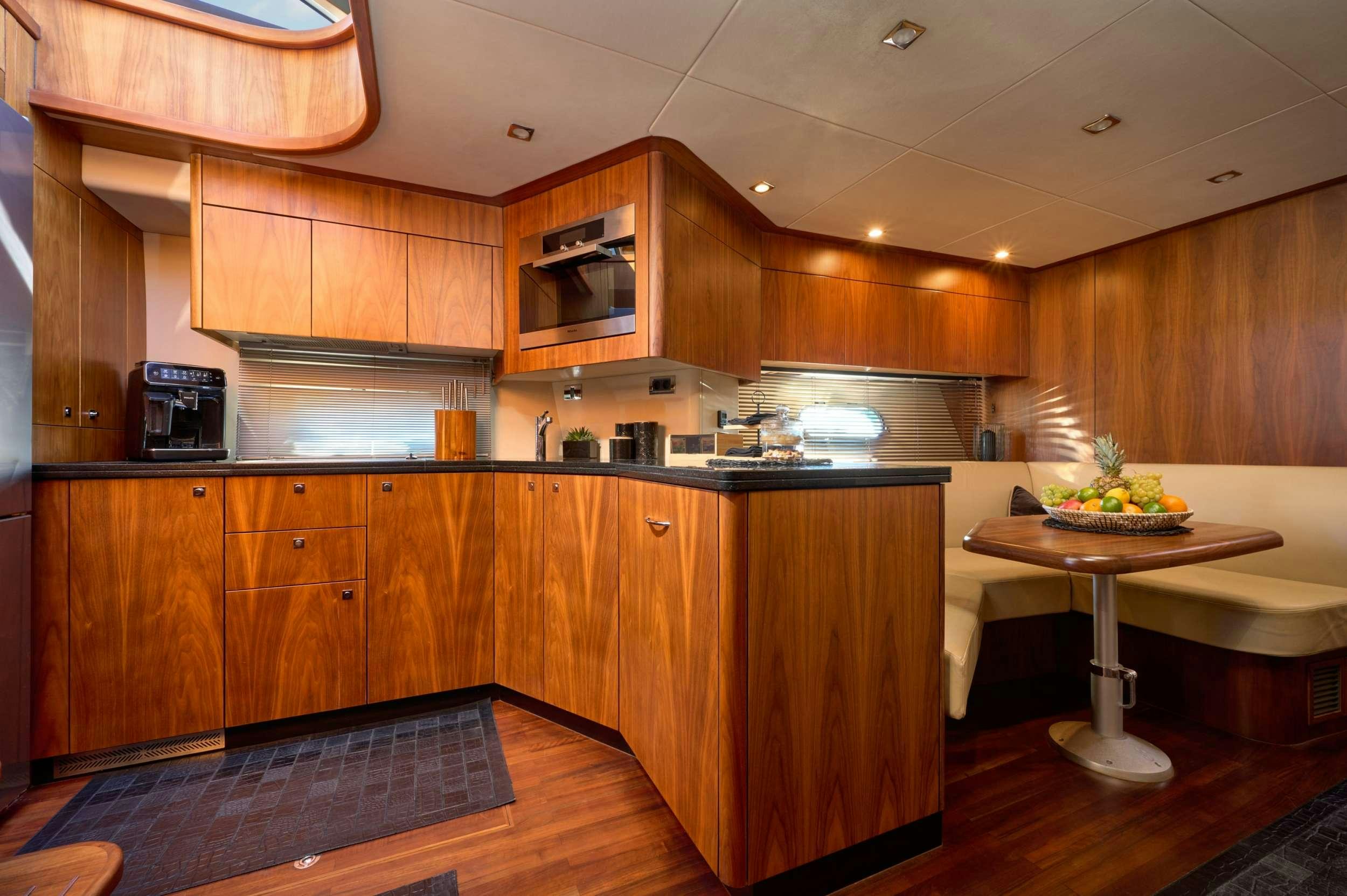 a kitchen with wooden cabinets aboard SUNSEEKER PREDATOR 72 GHOST Yacht for Charter
