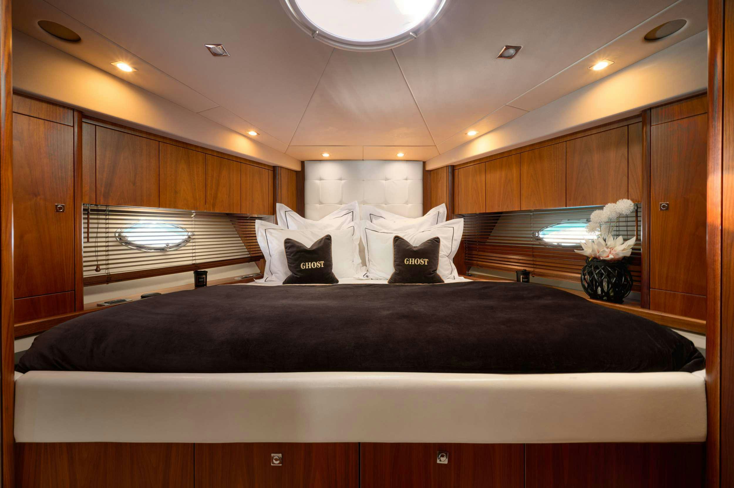 a bed with a black bed spread aboard SUNSEEKER PREDATOR 72 GHOST Yacht for Charter