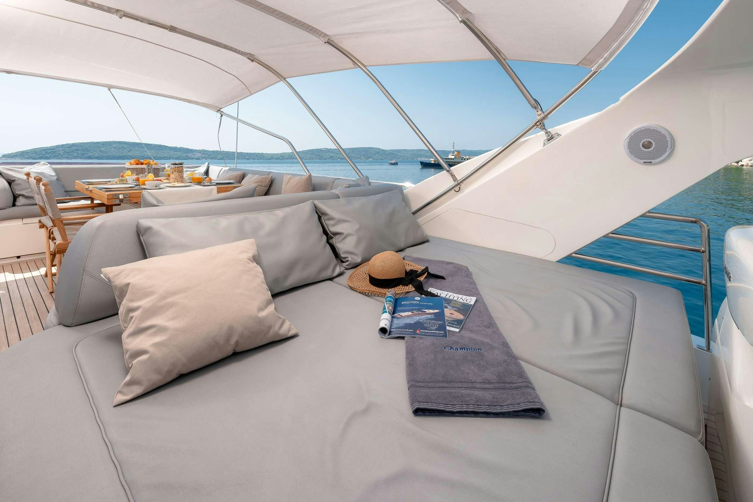 a bed with pillows and a hat on it aboard PRINCESS 72 FLY CHAMPION Yacht for Charter