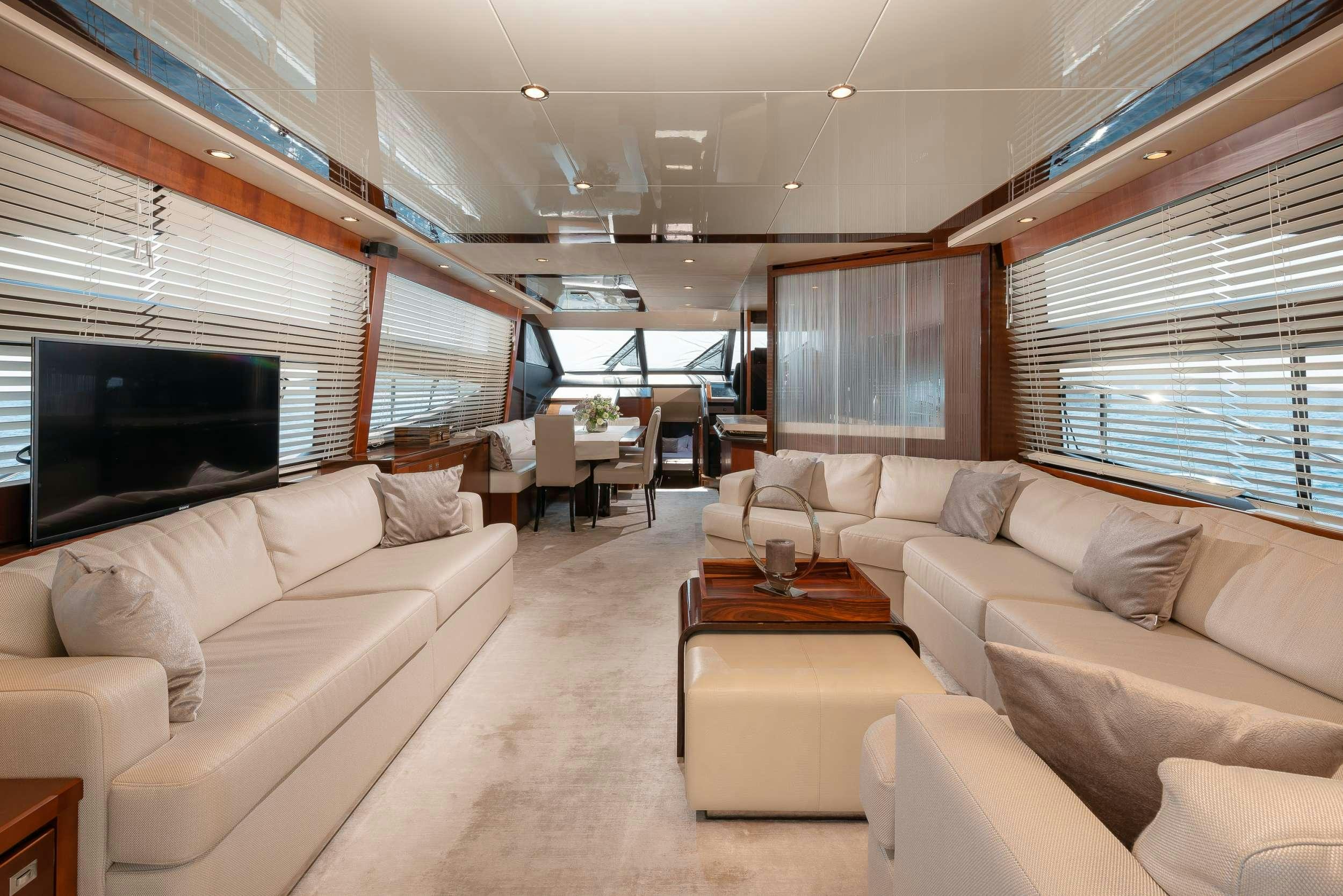 a living room with a couch and a television aboard PRINCESS 72 FLY CHAMPION Yacht for Charter