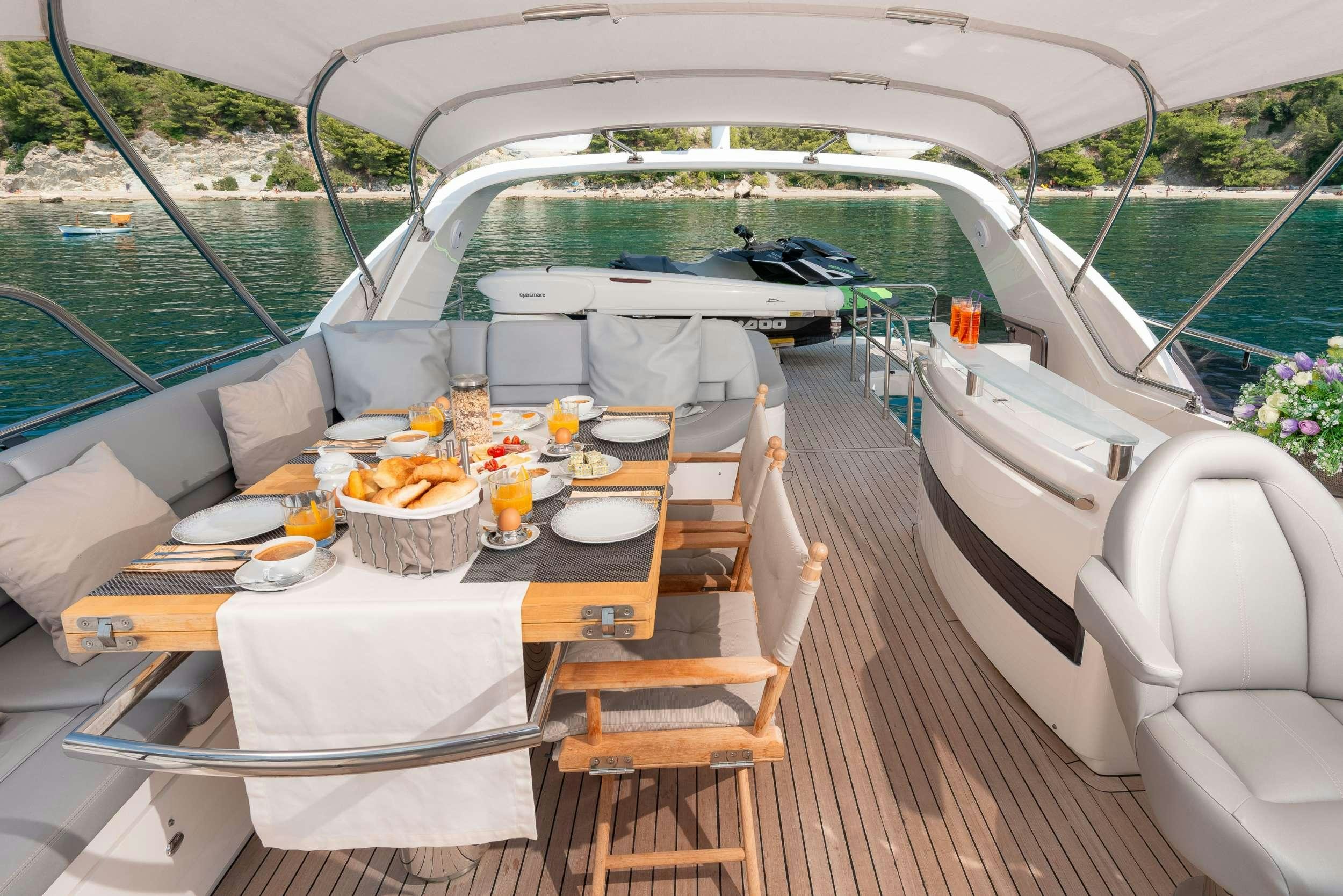 a boat with a table and chairs on it aboard PRINCESS 72 FLY CHAMPION Yacht for Charter