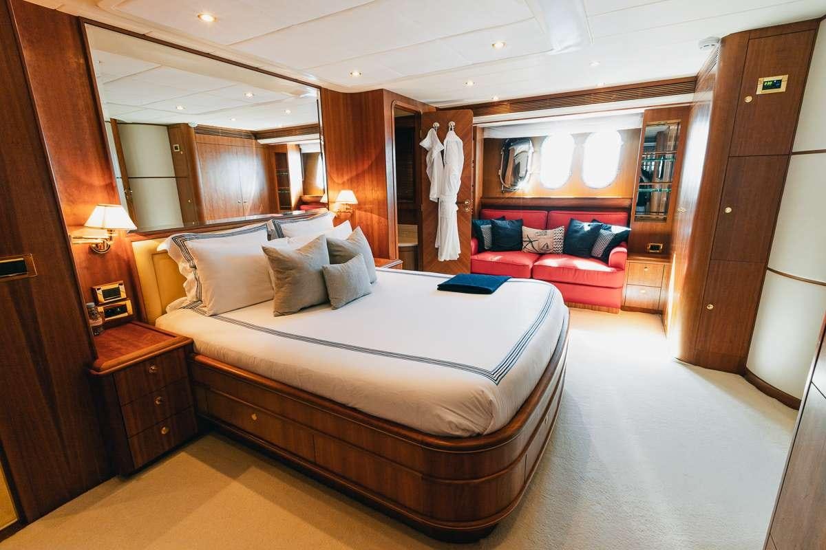 a hotel room with a bed and a couch aboard LADY AMANDA Yacht for Charter