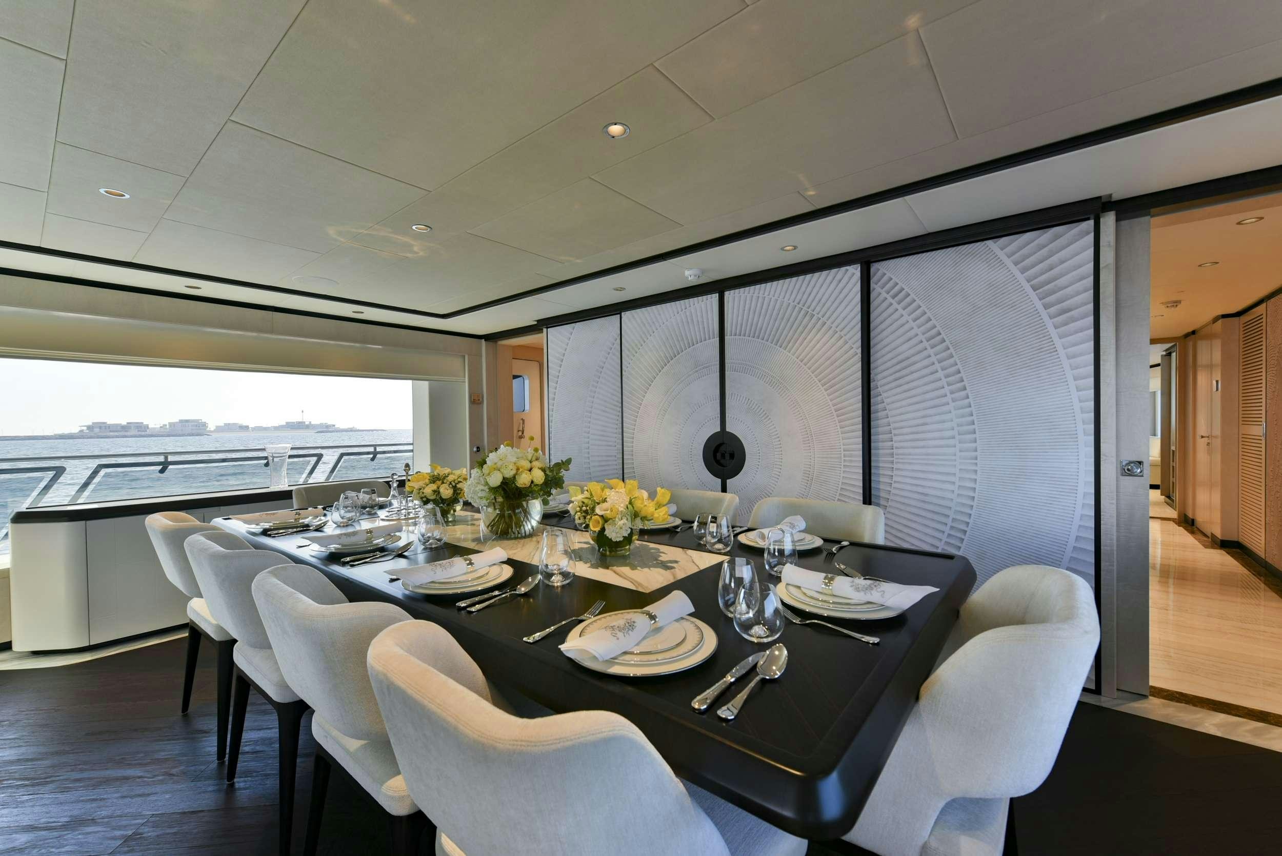 a dining table with white chairs aboard ROCKET ONE Yacht for Charter