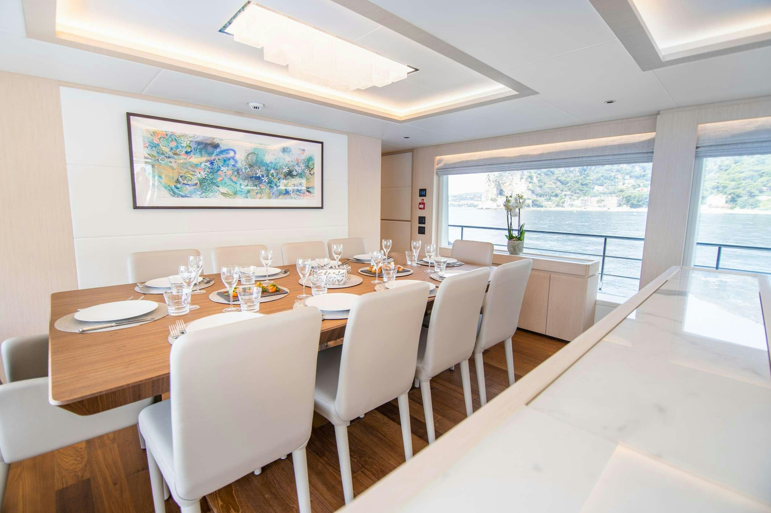 a large dining table with white chairs aboard OCEAN VIEW Yacht for Charter