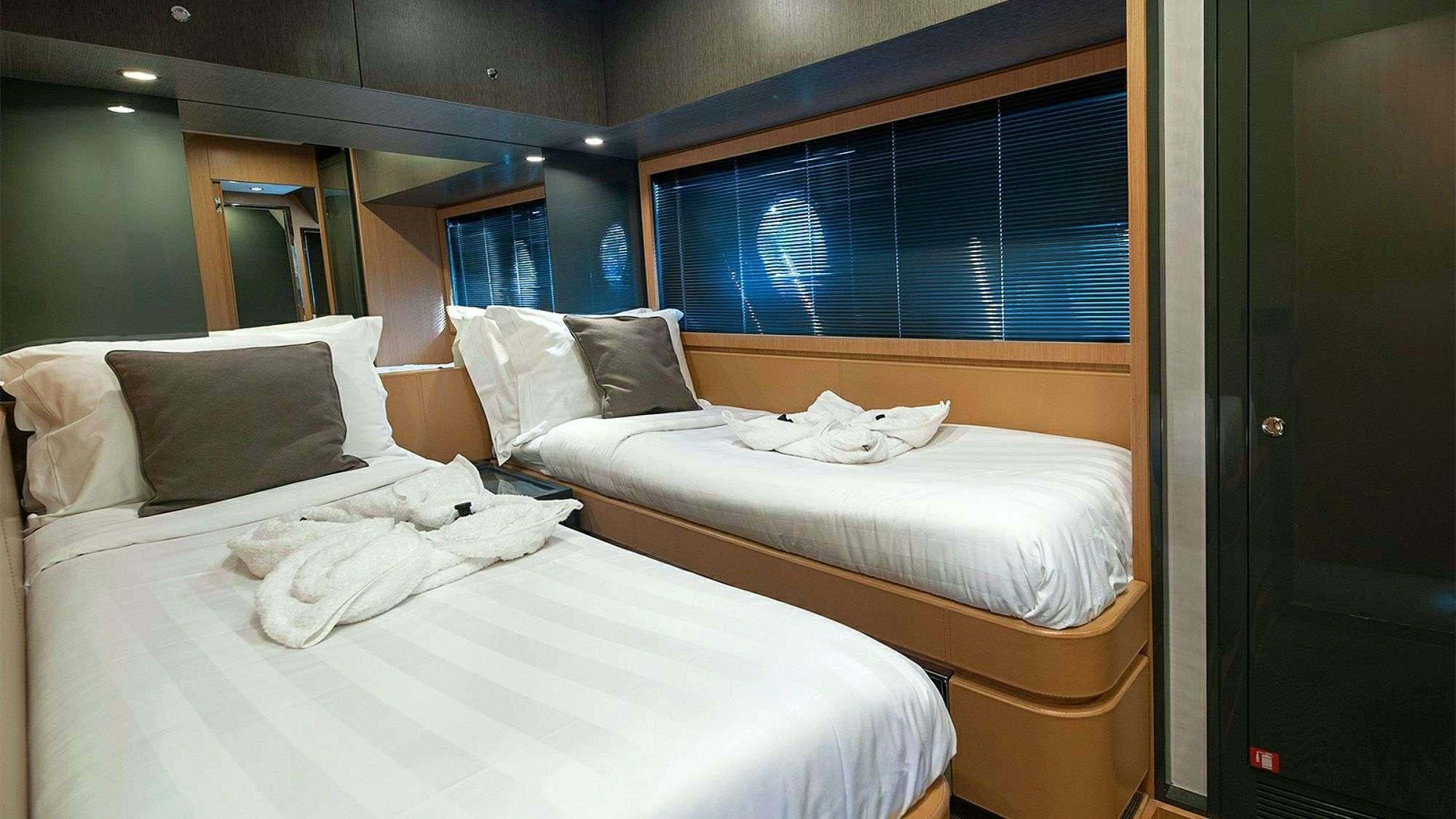 a room with beds and a window aboard WHATEVER Yacht for Charter