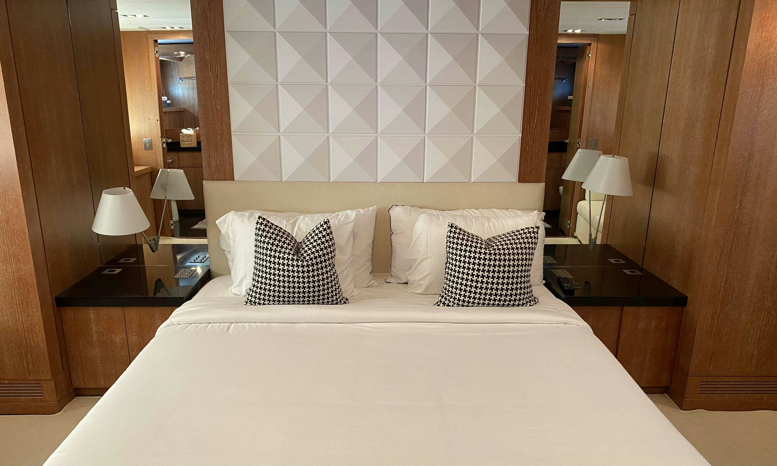 a bed with white sheets aboard SMILE Yacht for Charter