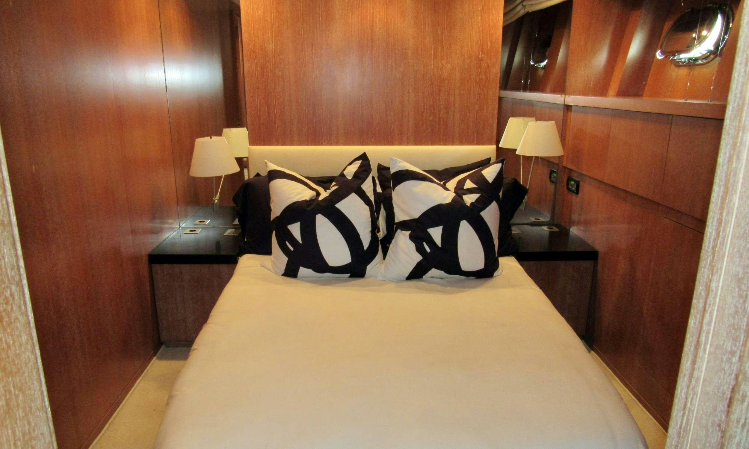 a bed with a white sheet and pillows on it aboard SMILE Yacht for Charter