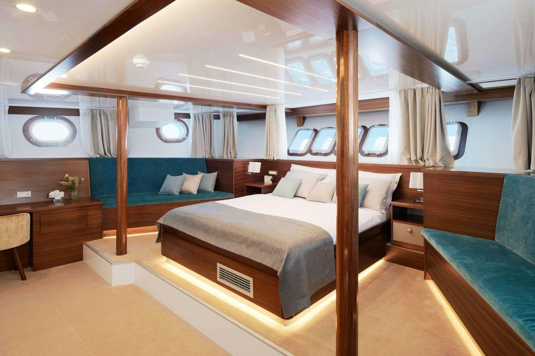 a room with a bed and a desk aboard CORSARIO Yacht for Charter