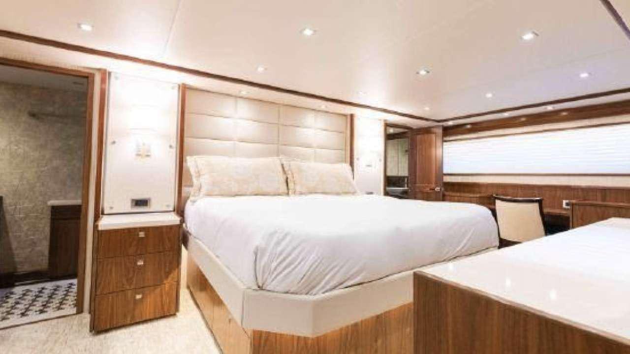 a room with a bed and a chair aboard TOUCHE Yacht for Charter