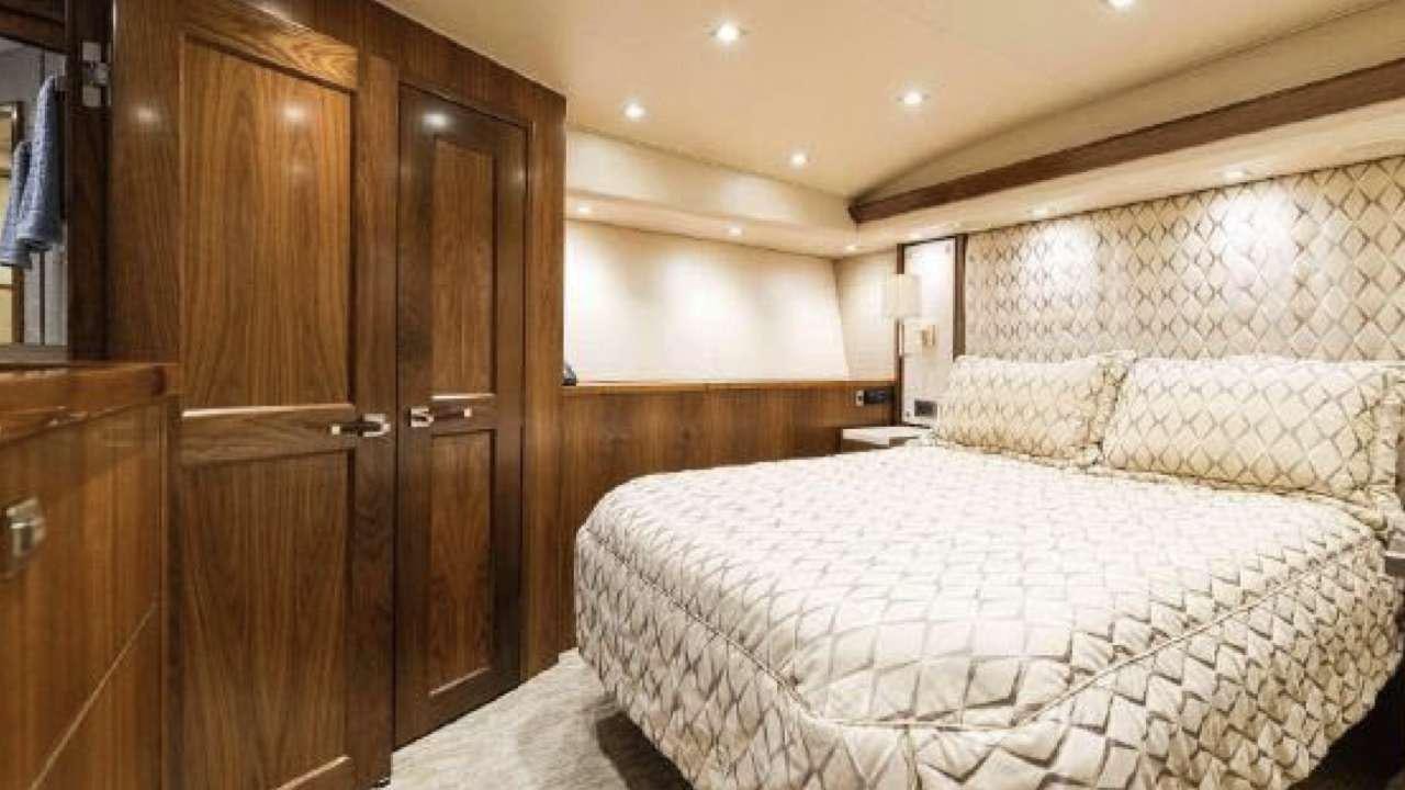 a bedroom with a bed and a closet aboard TOUCHE Yacht for Charter