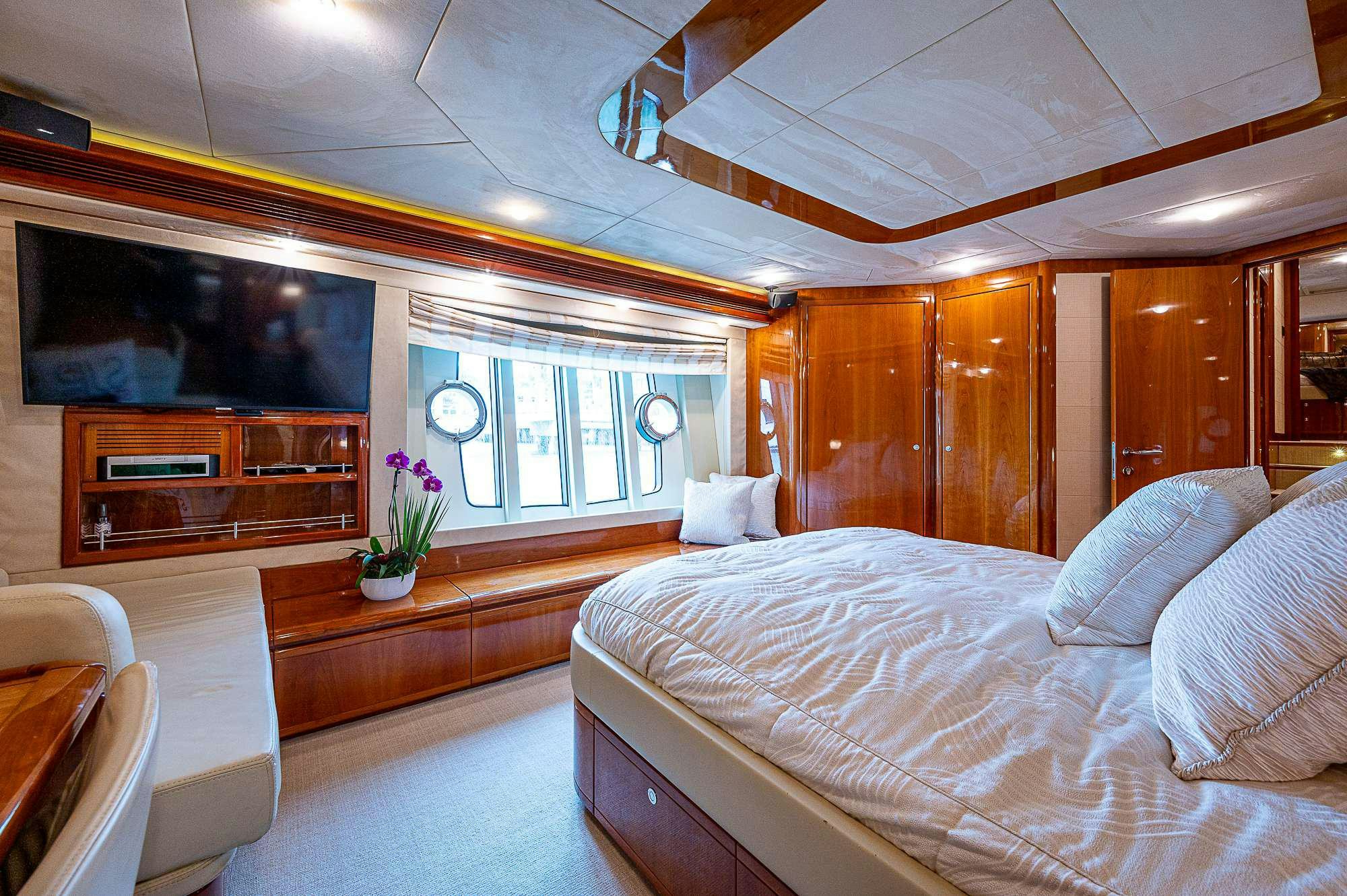 a room with a bed and a television aboard LA PALOMA  Yacht for Charter