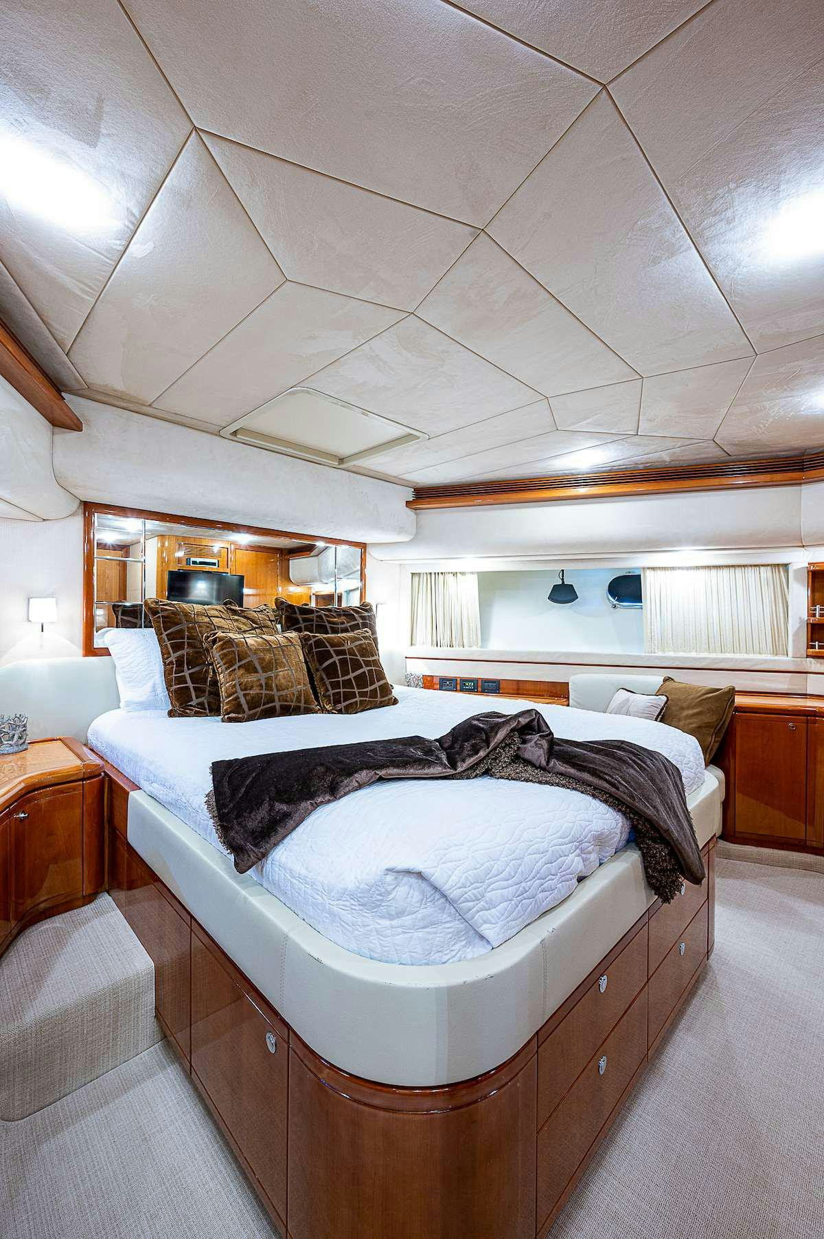 a bedroom with a bed and a television aboard LA PALOMA  Yacht for Charter