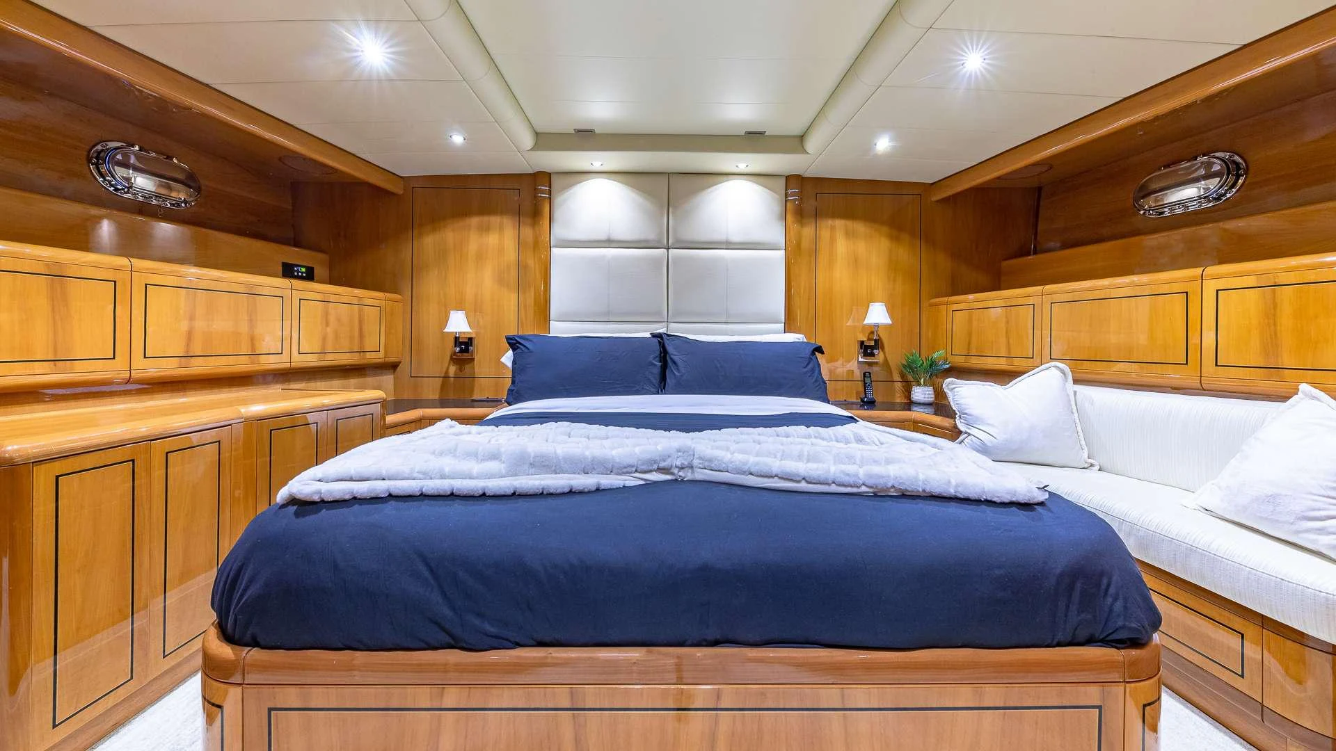 a bed with a blue comforter aboard HAPPY Yacht for Charter