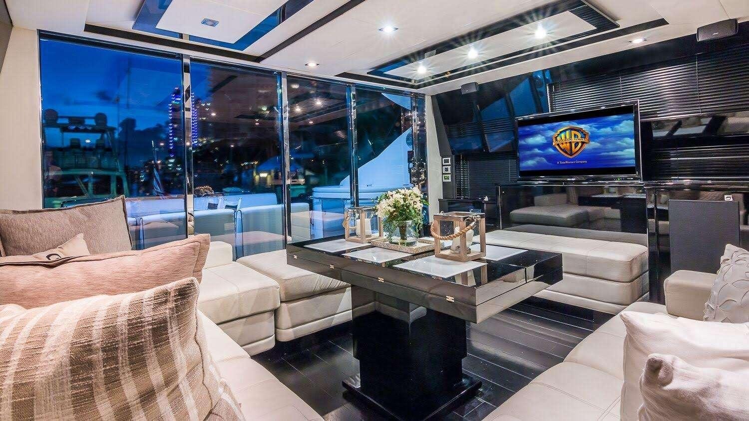 a room with a tv and couches aboard ALL IN Yacht for Charter