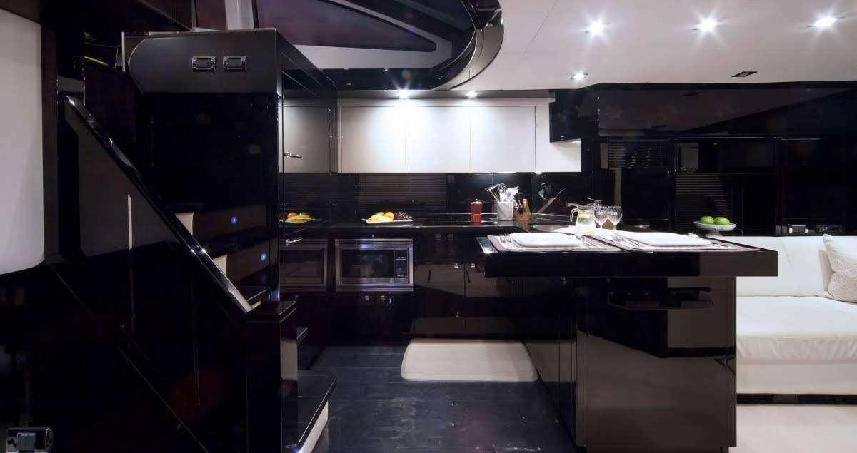 a large kitchen with black cabinets aboard ALL IN Yacht for Charter