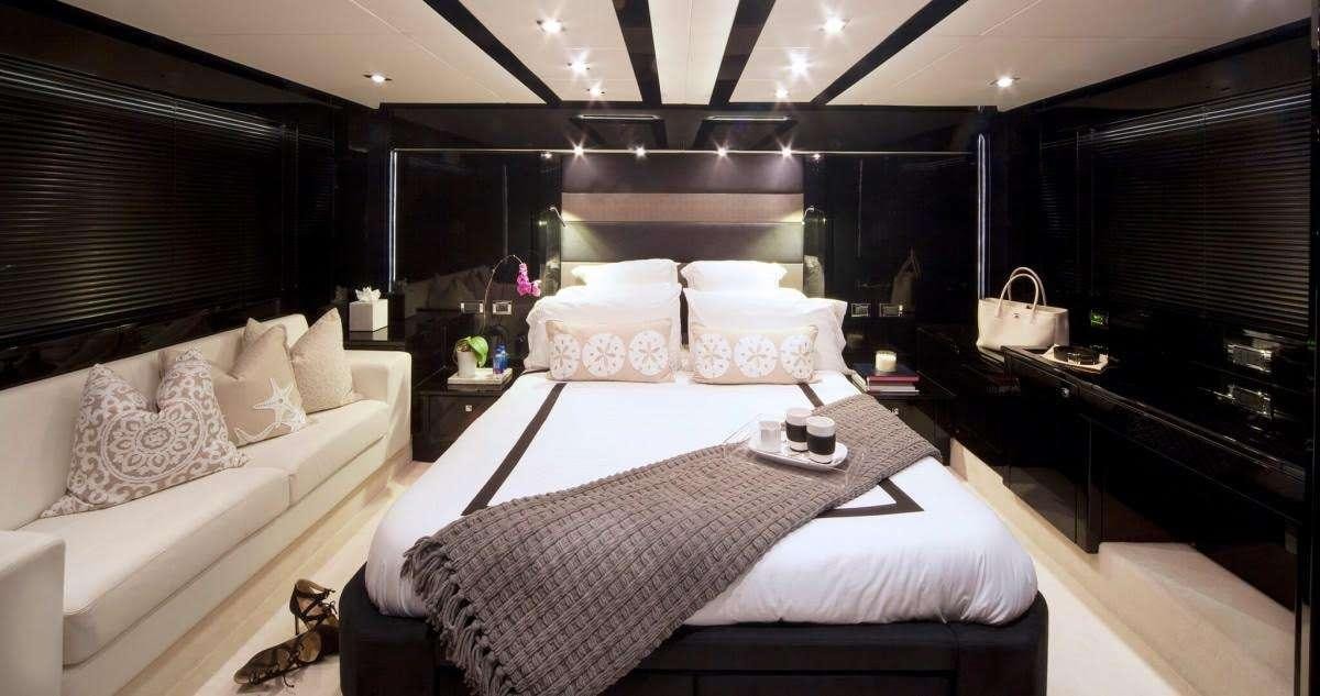 a bed with a white bed spread aboard ALL IN Yacht for Charter