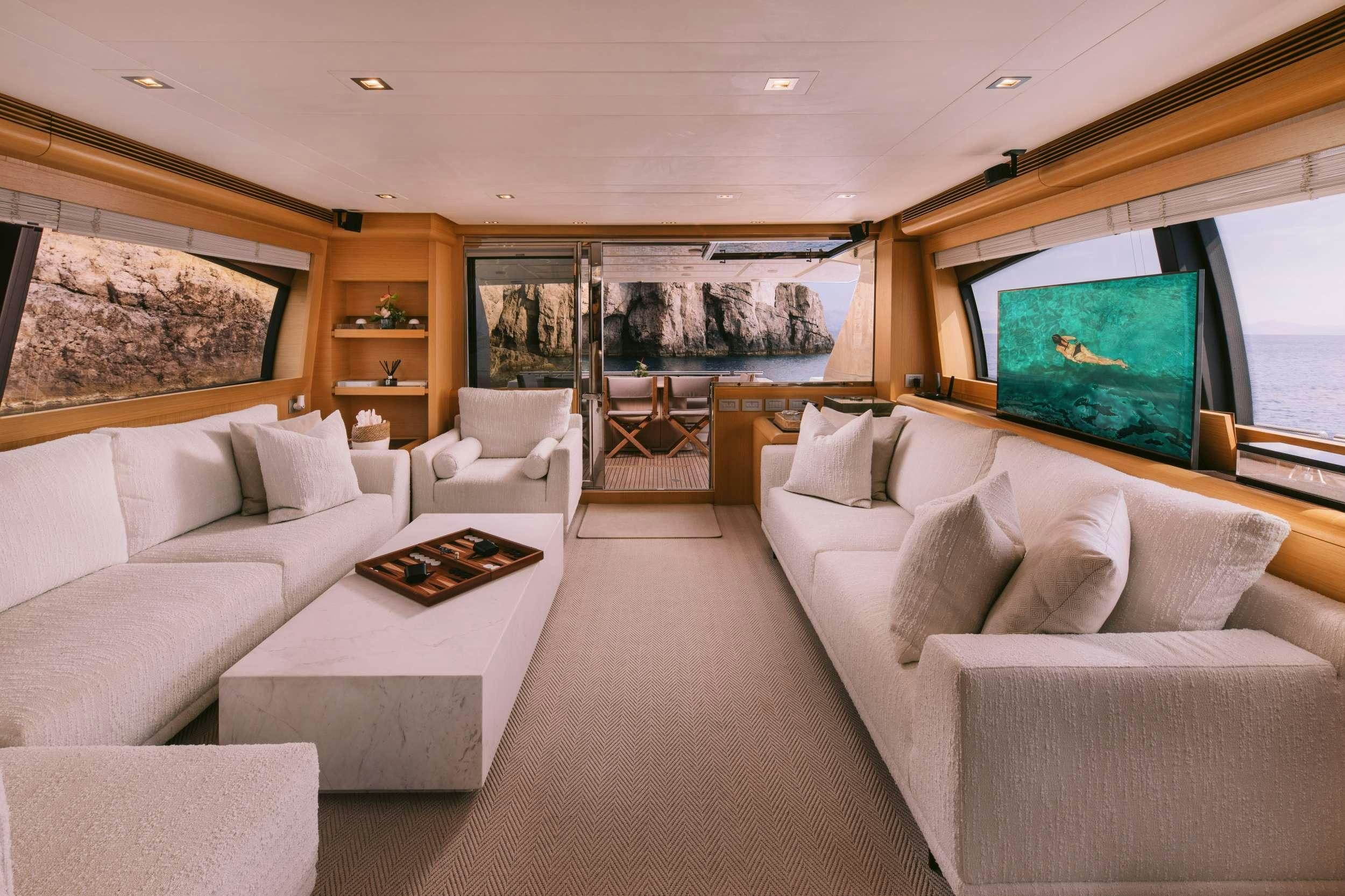 a living room with white couches and a tv aboard D&AMP;D Yacht for Charter