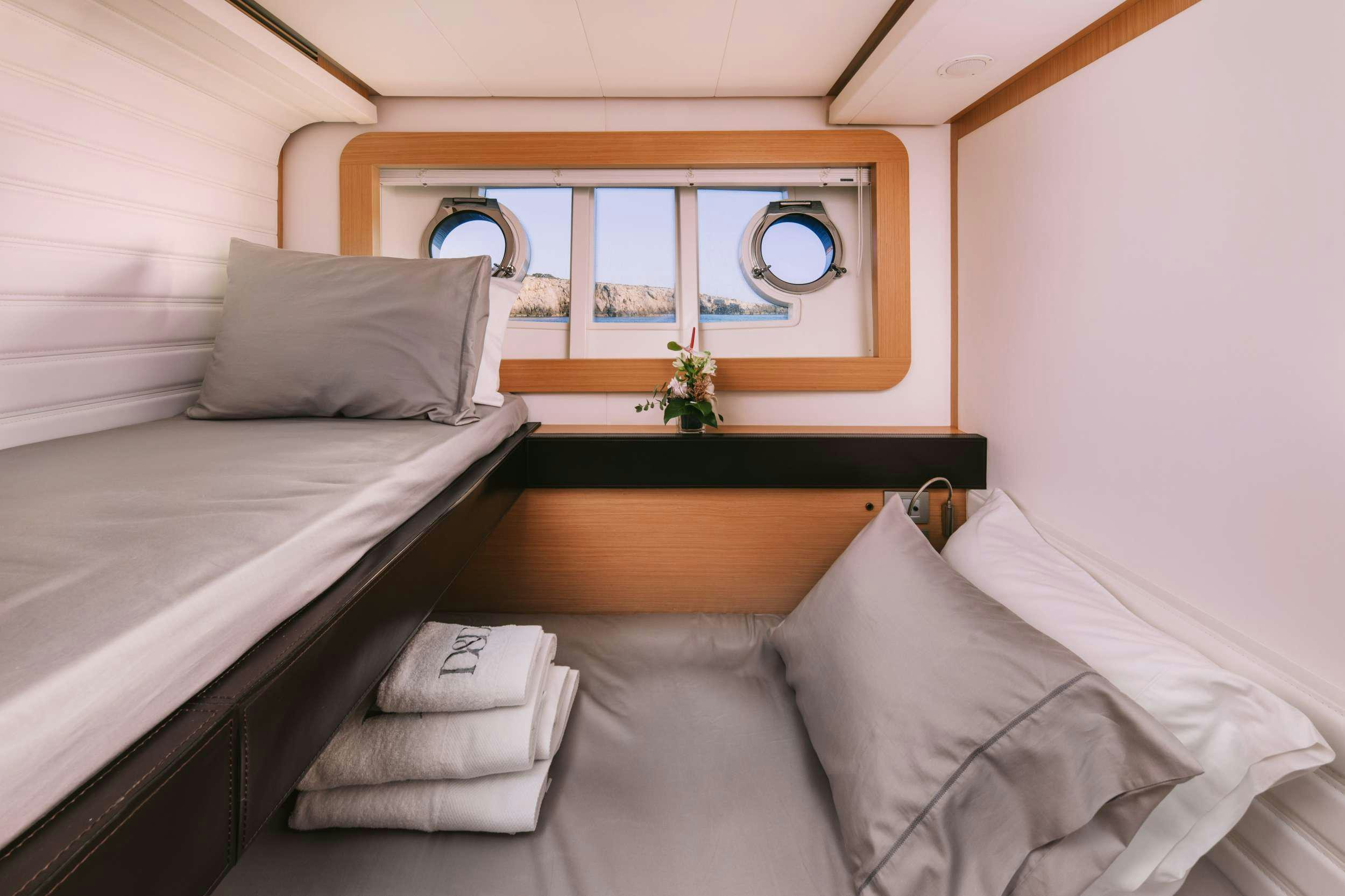 a bed with white sheets and pillows aboard D&AMP;D Yacht for Charter