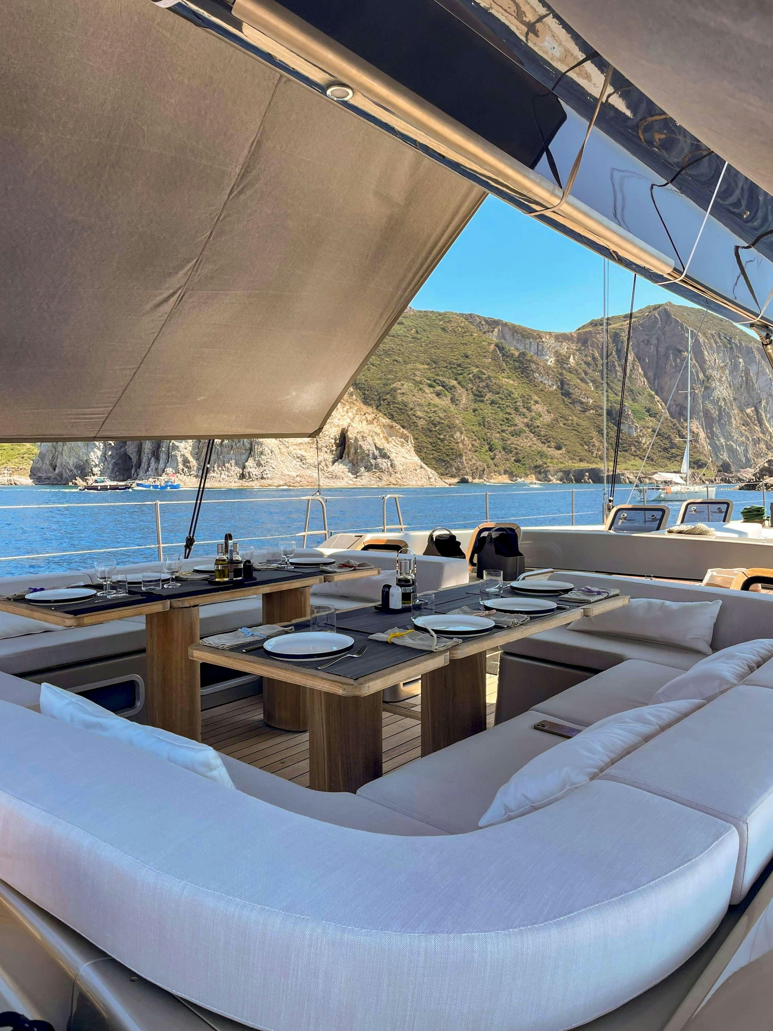 a boat with a table and chairs aboard RUNNING ON FAITH Yacht for Charter