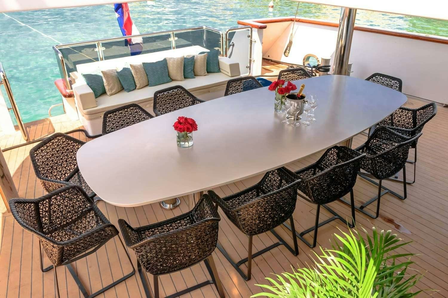a table with chairs around it aboard OMNIA Yacht for Charter