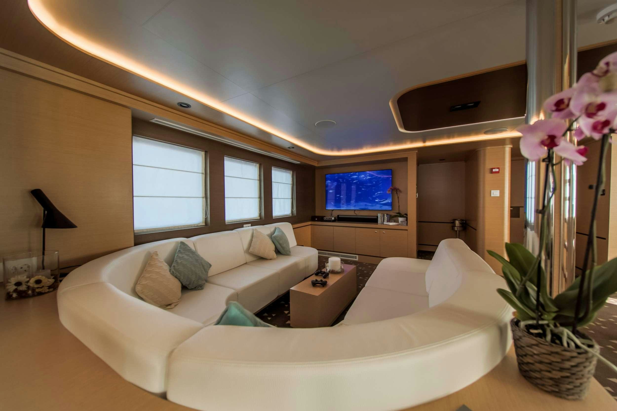 a living room with a large television aboard OMNIA Yacht for Charter