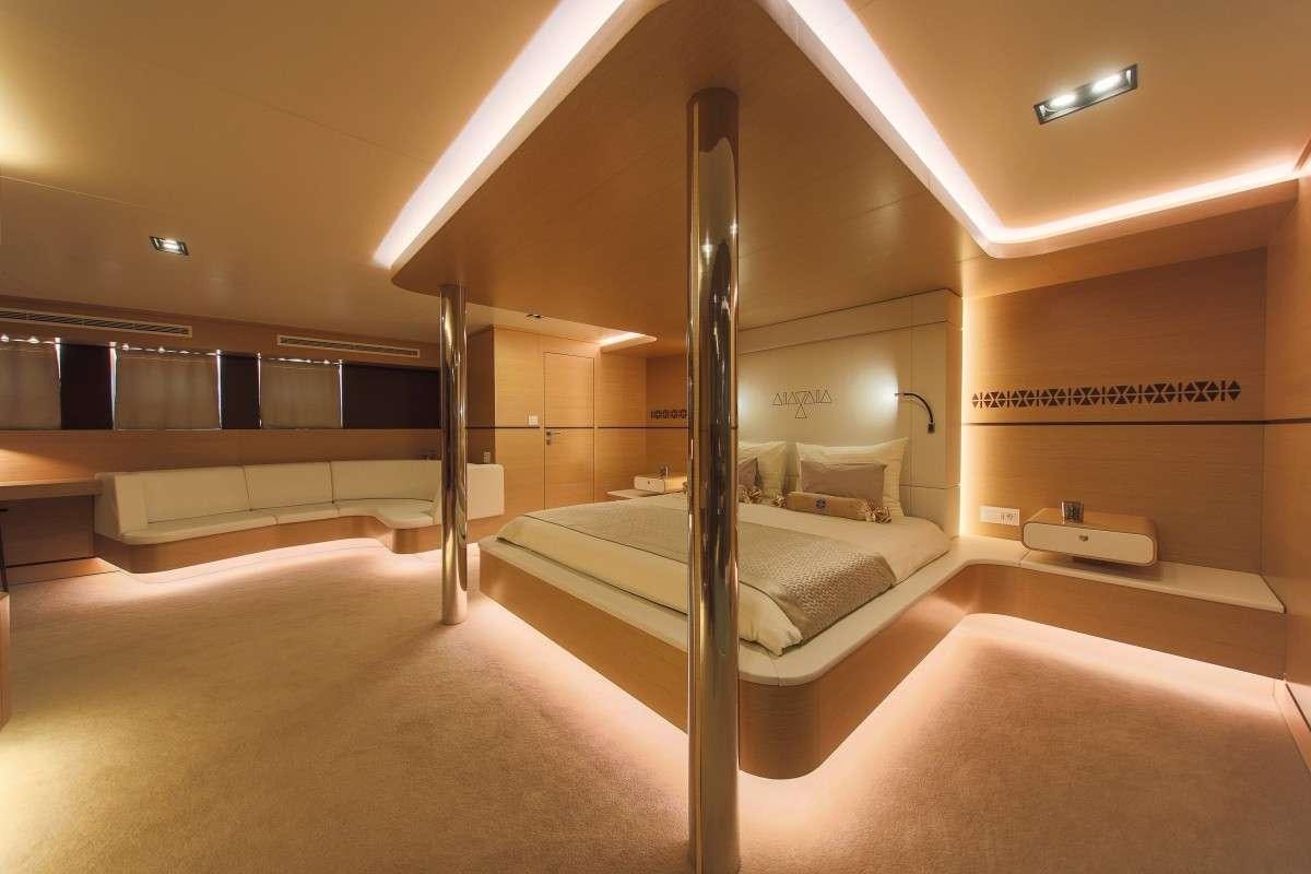 a room with a bed and a large mirror aboard OMNIA Yacht for Charter