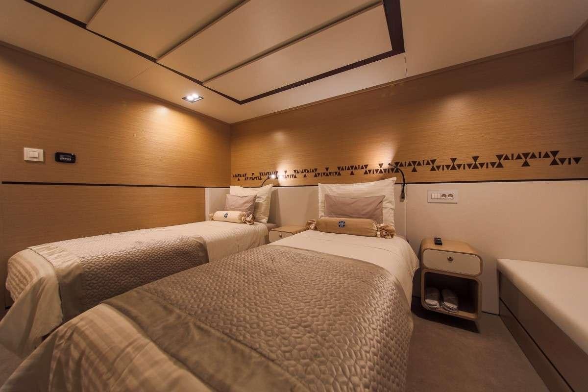 a room with two beds aboard OMNIA Yacht for Charter