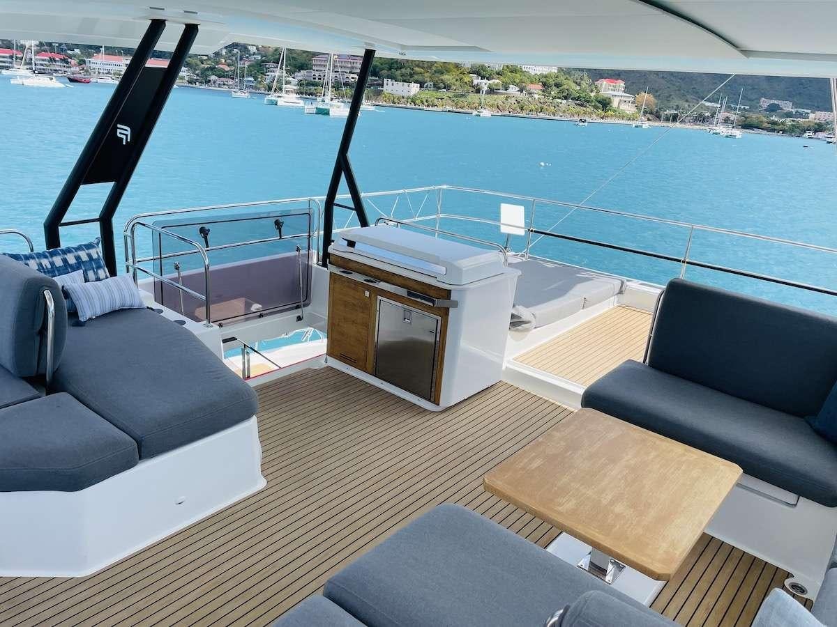 a deck with a pool and a deck with chairs and a table aboard TRU NORTH Yacht for Charter