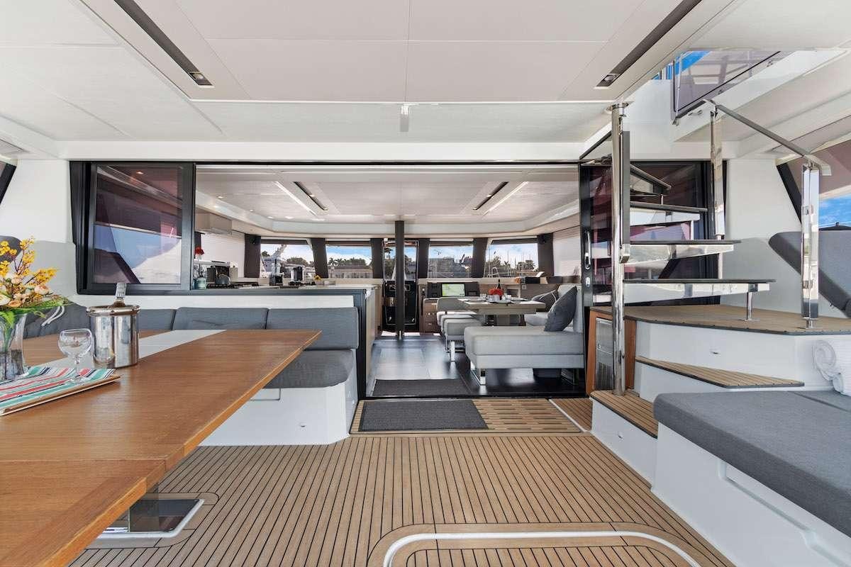 a room with a wood floor and a wood table and a large window aboard TRU NORTH Yacht for Charter