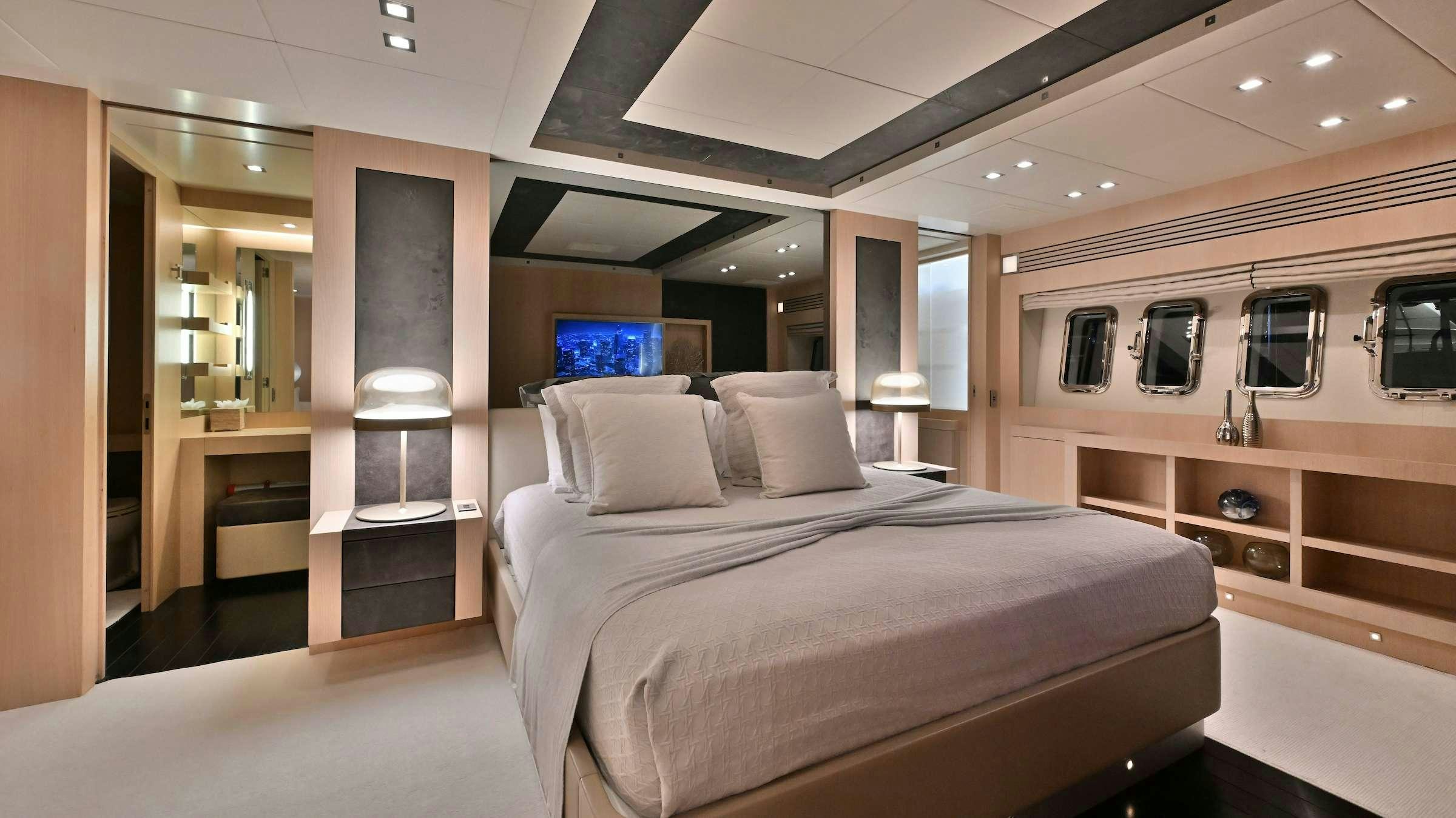 a room with a bed and a desk aboard TOTAL Yacht for Charter