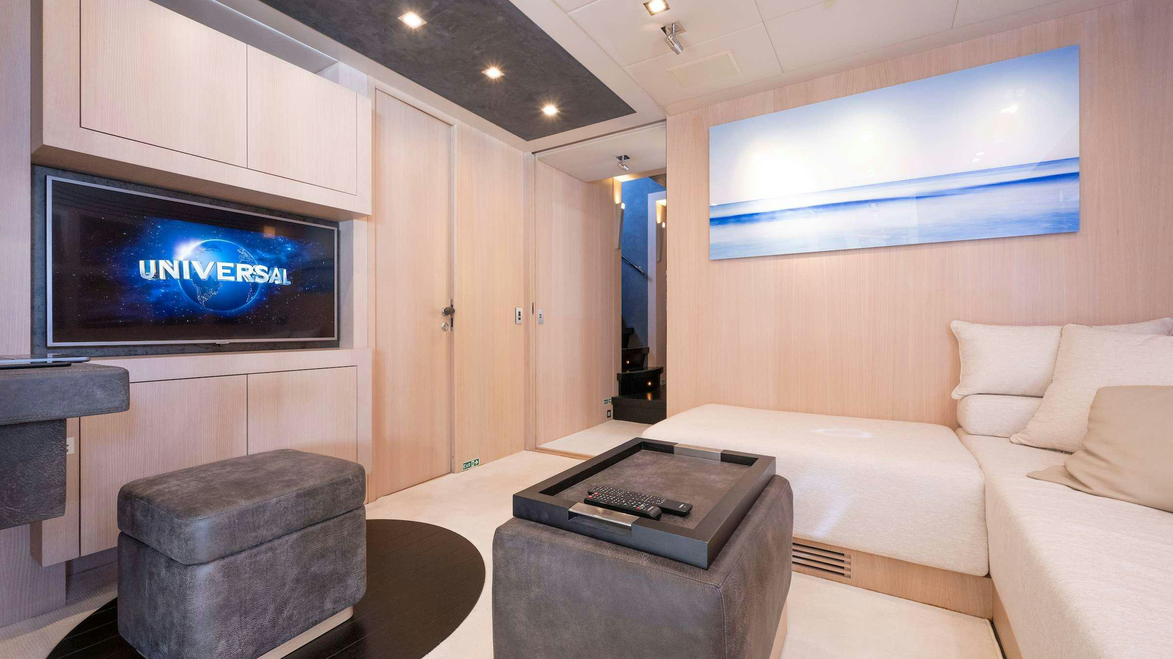 a living room with a large tv aboard TOTAL Yacht for Charter