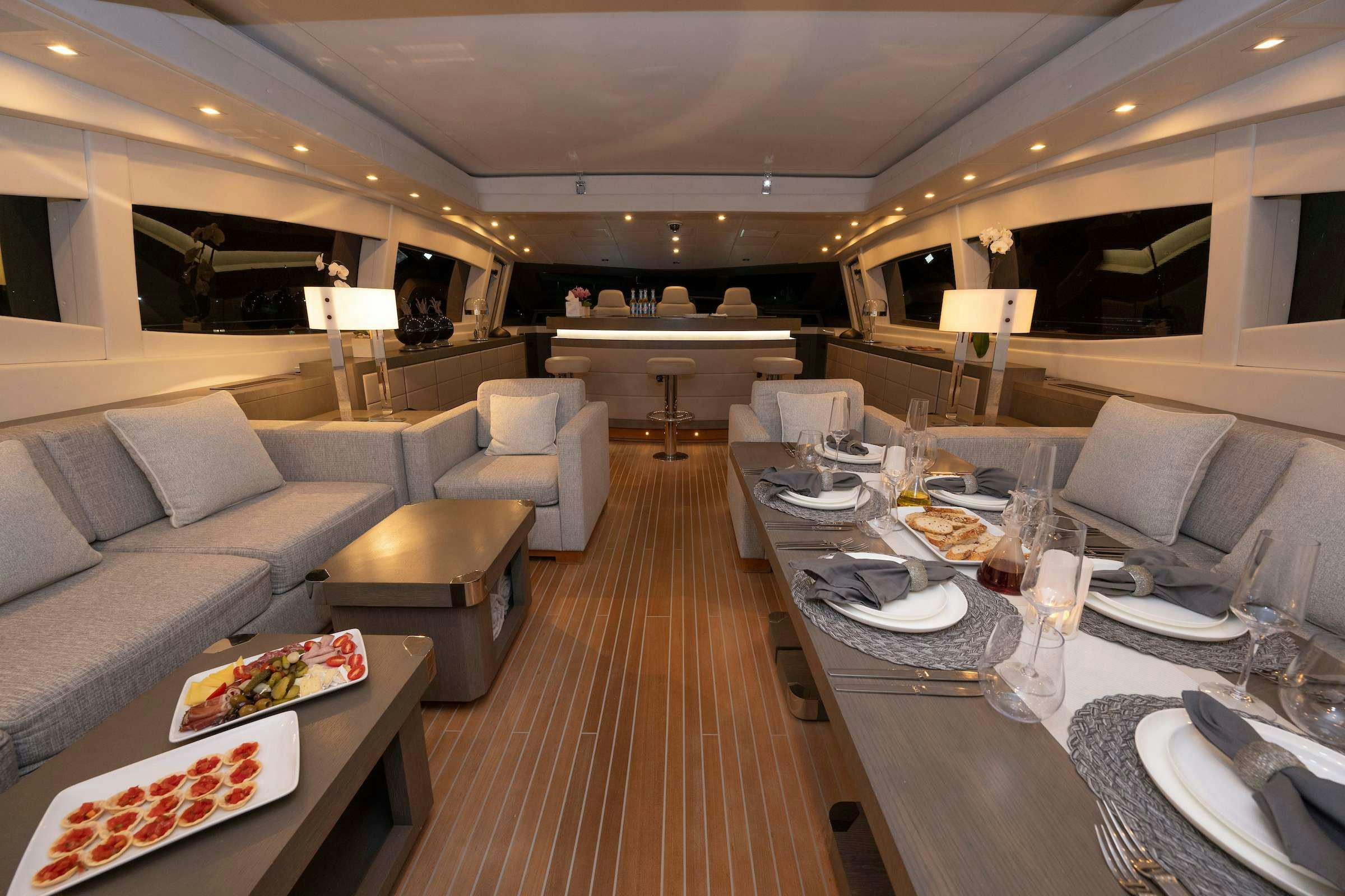 a living room with a table and chairs aboard TOTAL Yacht for Charter