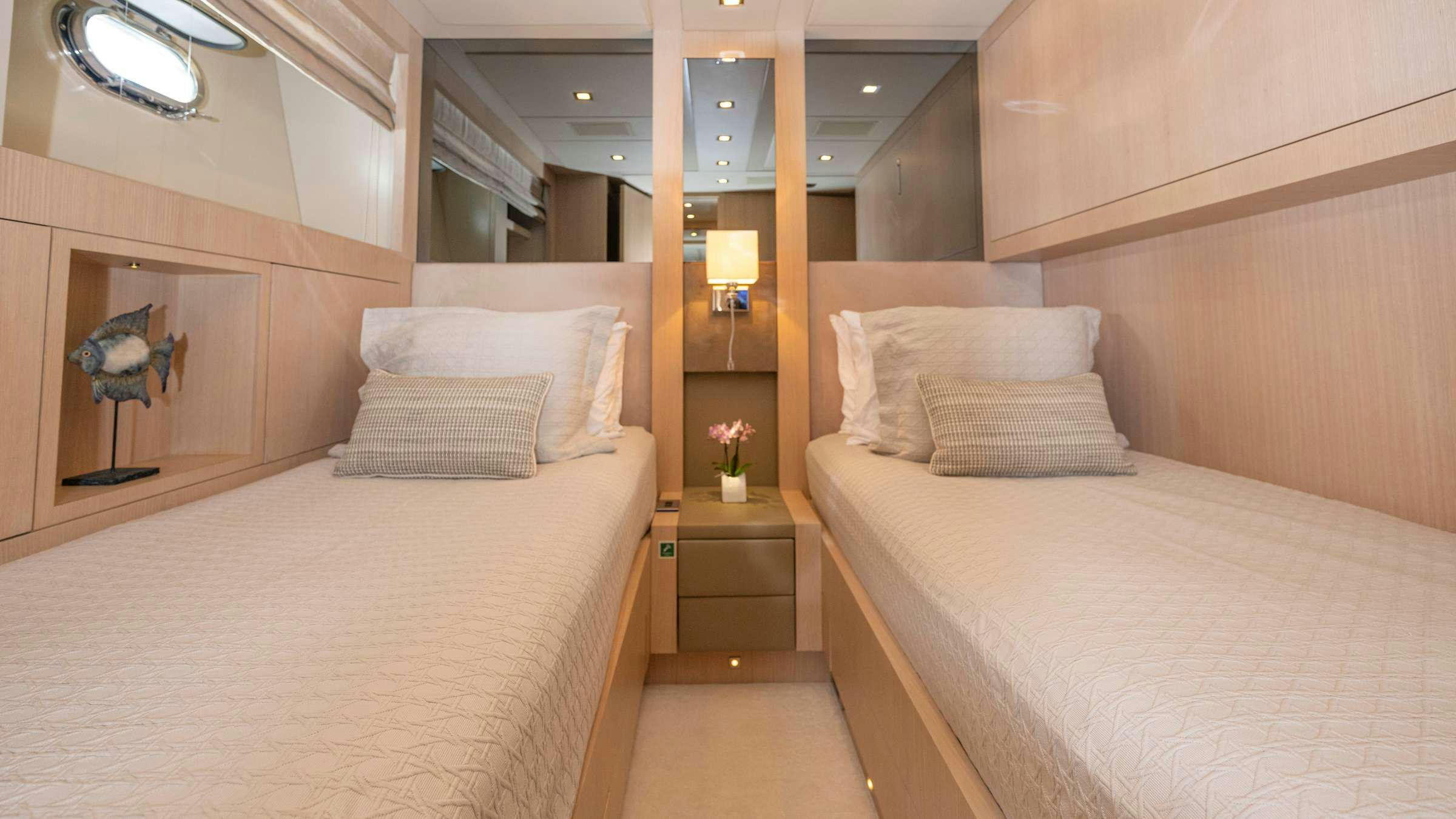 a room with a bed and a mirror aboard TOTAL Yacht for Charter