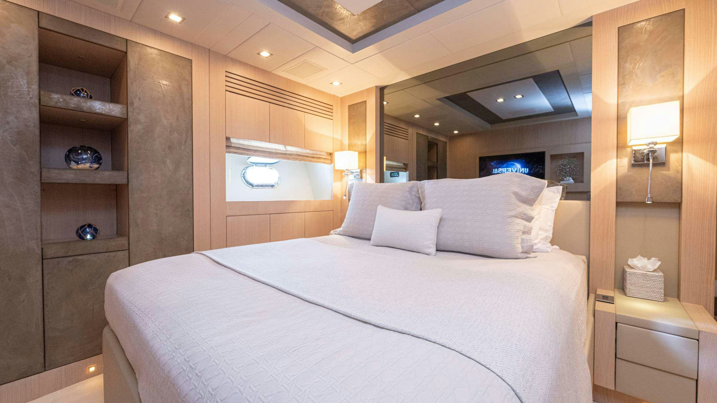 a bed with white sheets and pillows aboard TOTAL Yacht for Charter