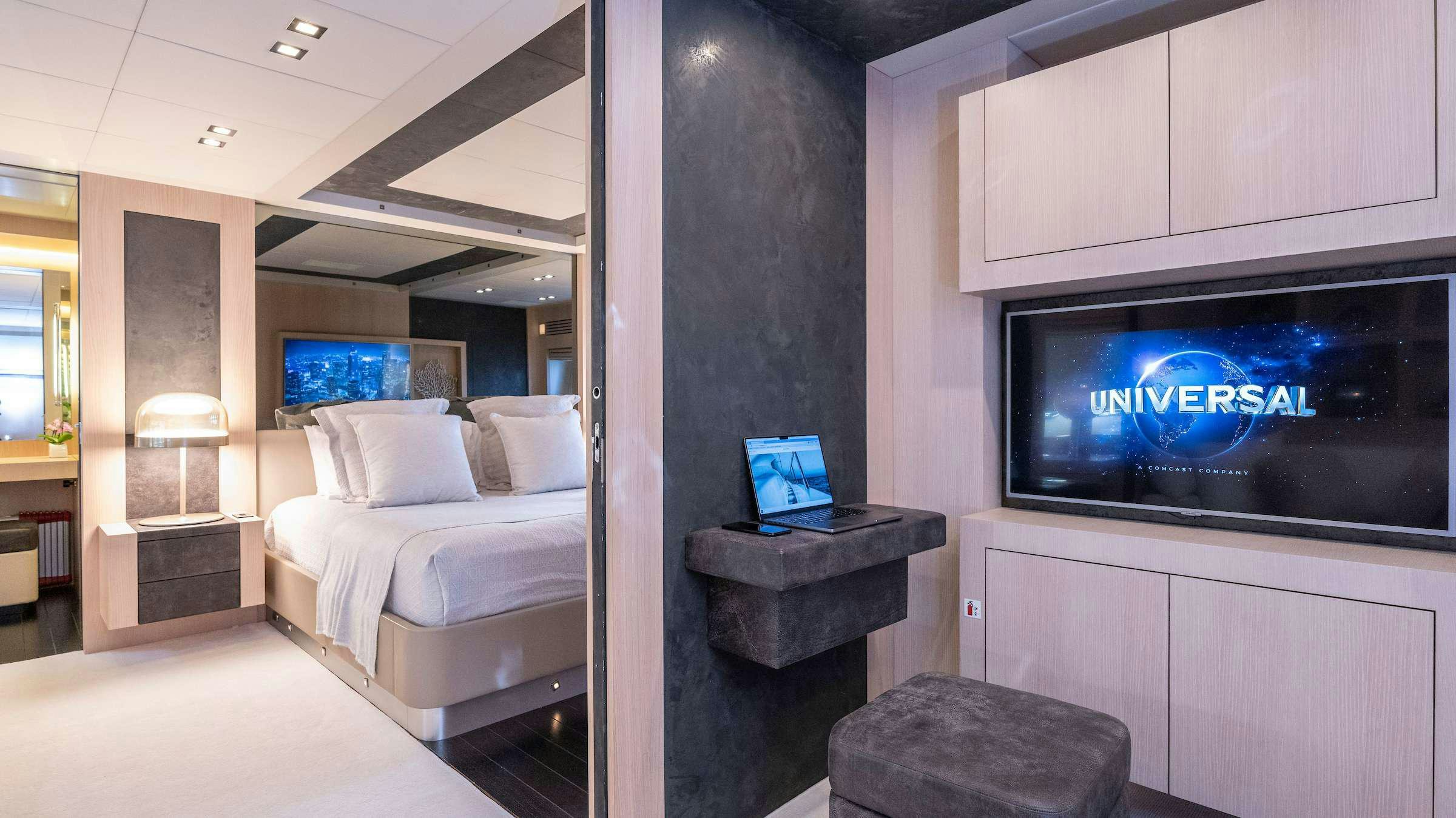 a room with a bed and a tv aboard TOTAL Yacht for Charter