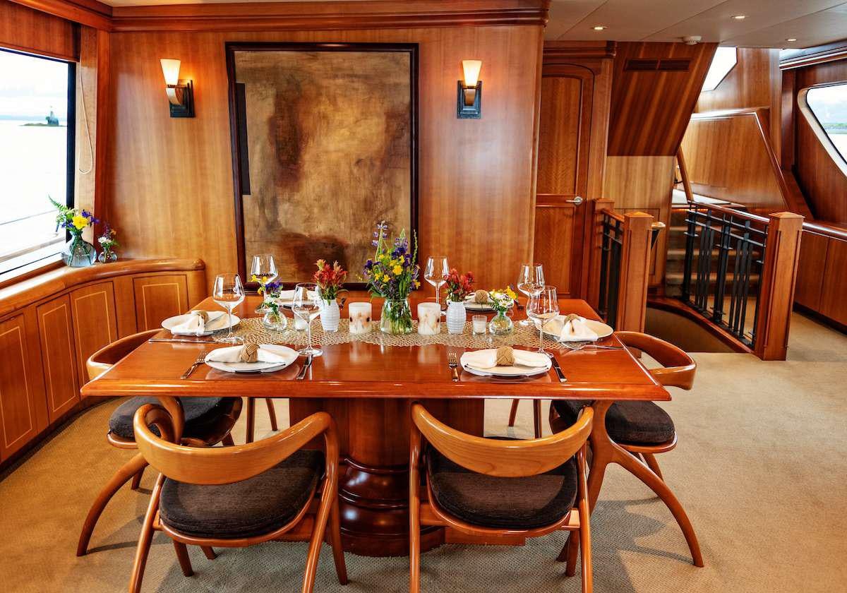 a dining table with chairs aboard DAUNTLESS Yacht for Charter