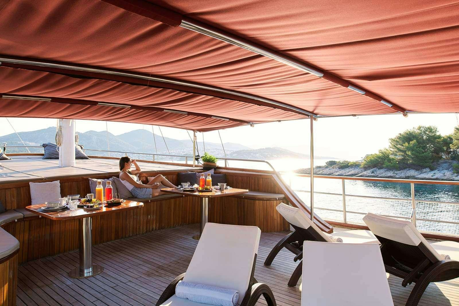 a person sitting at a table on a boat aboard CATALEYA Yacht for Charter