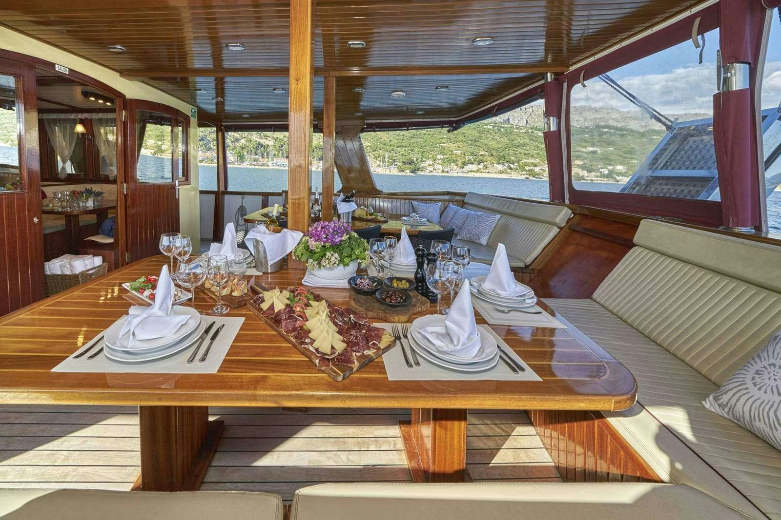 a table with plates and flowers aboard CATALEYA Yacht for Charter