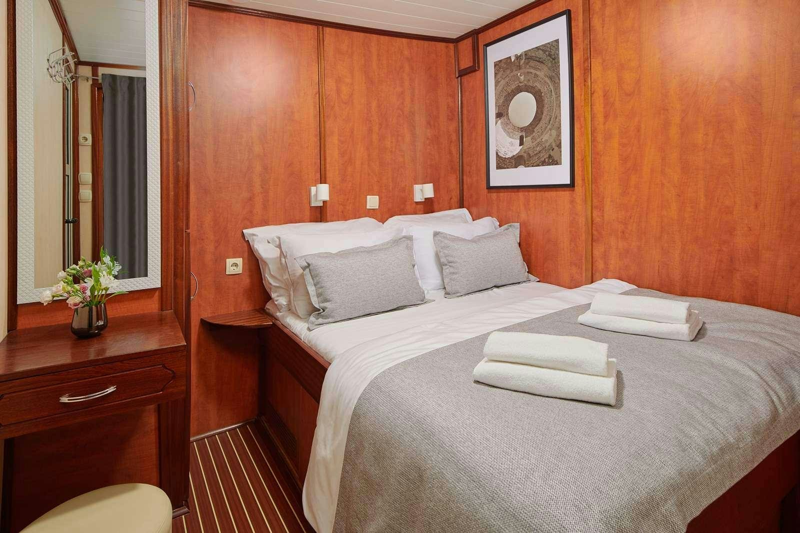 a bed with white sheets and pillows aboard CATALEYA Yacht for Charter